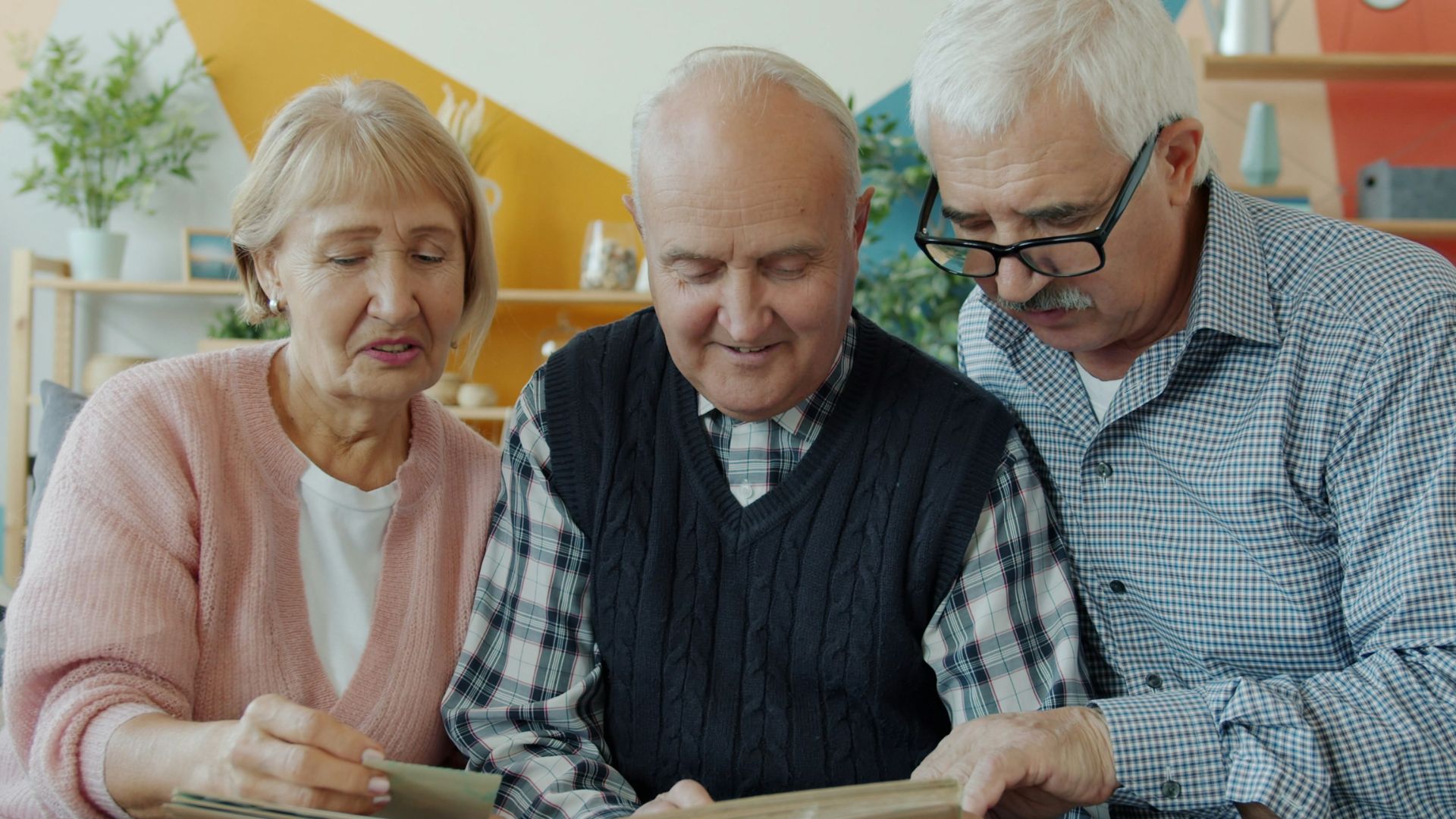 Three seniors looking at a photo album together