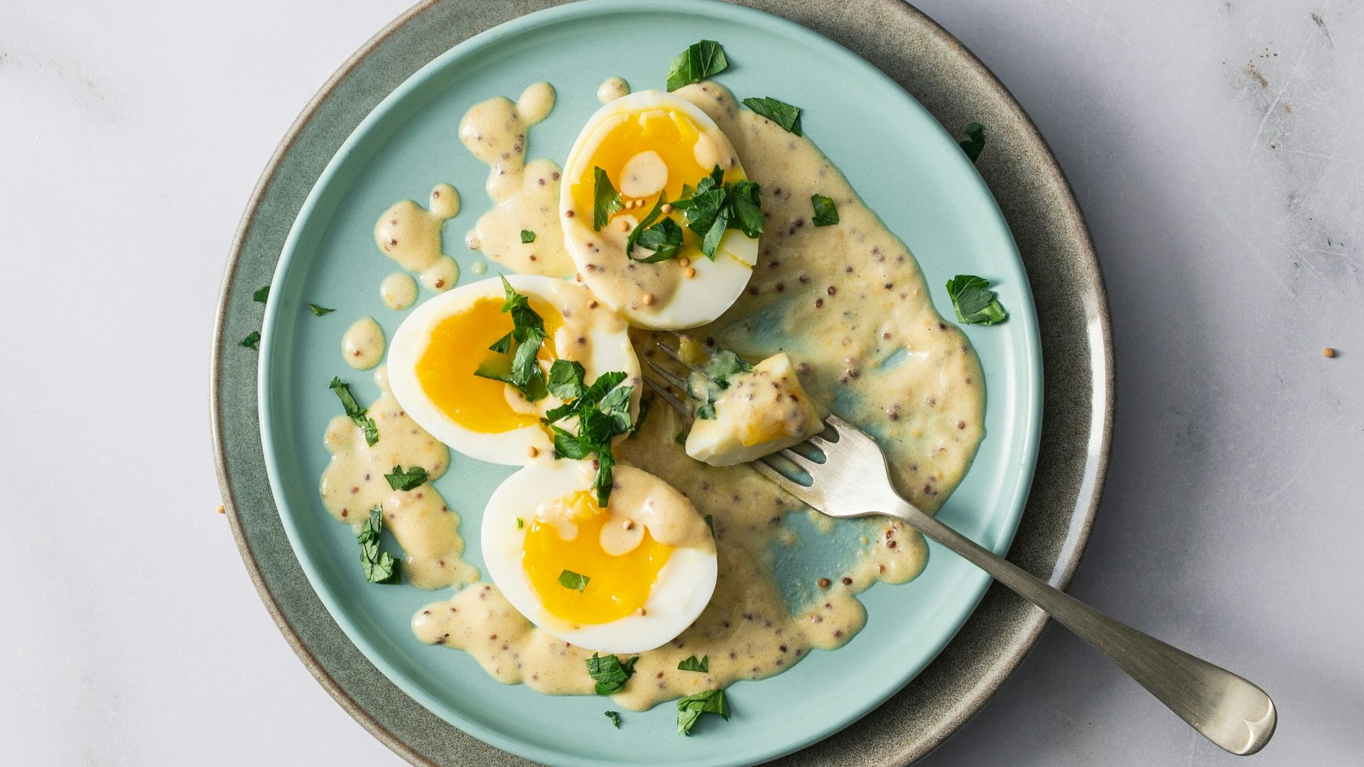 a blue plate topped with eggs and pasta