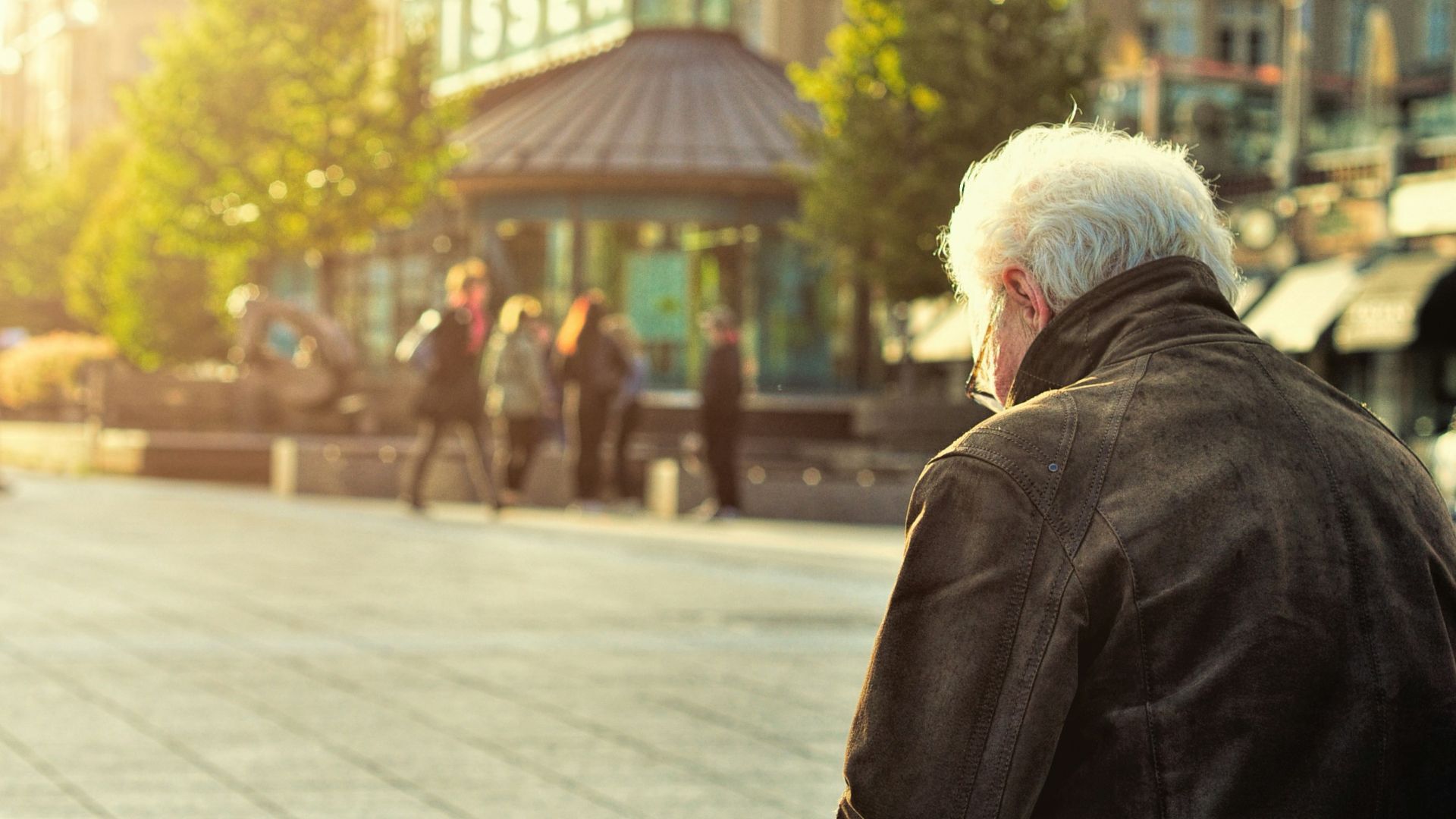 man sitting on brown wooden bench