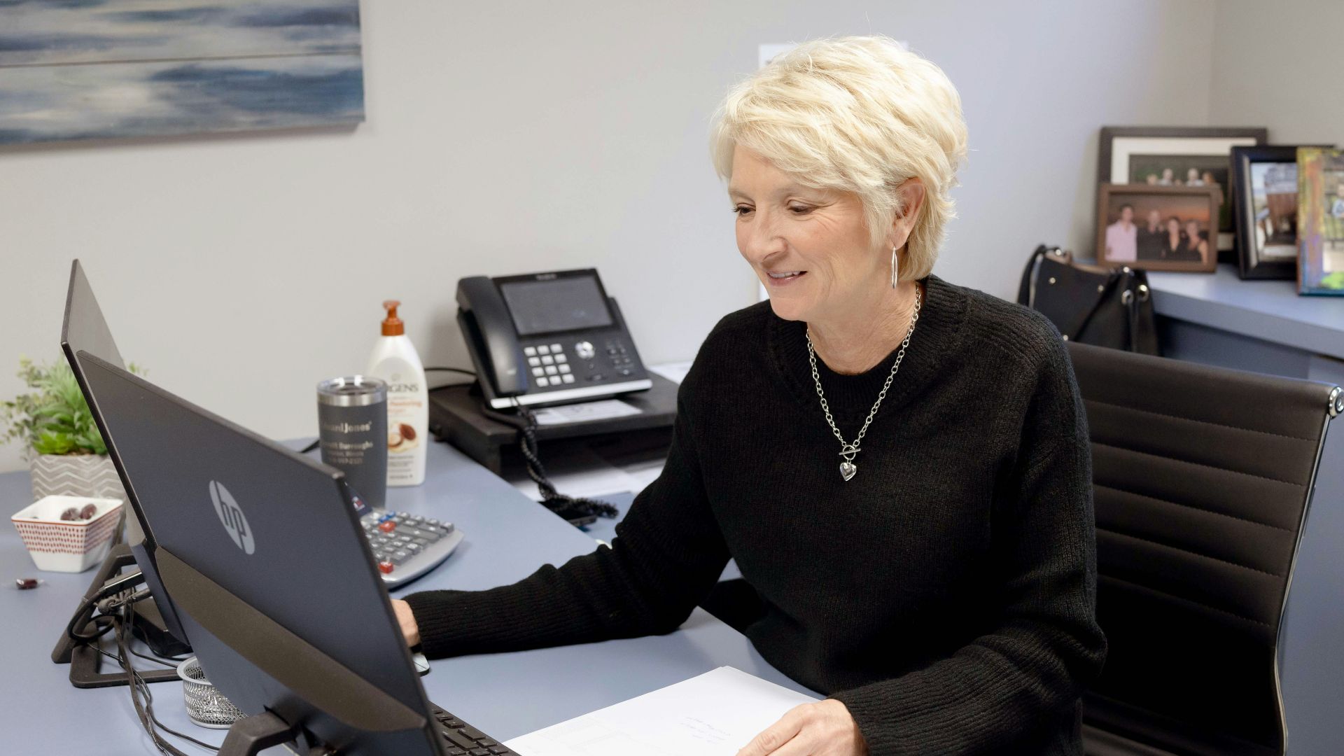 Woman works on laptop at her office desk.