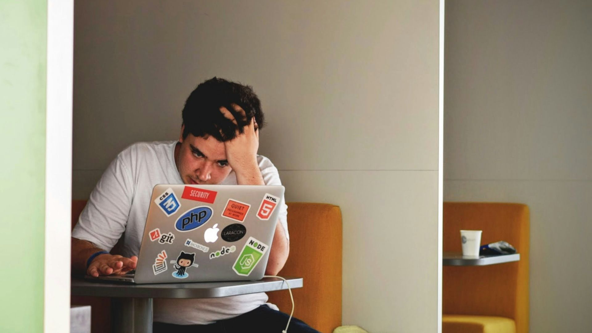 man wearing white top using MacBook