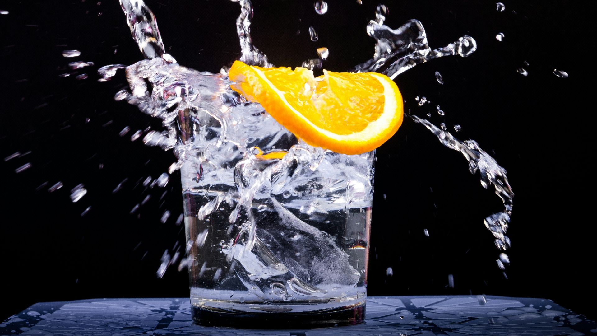 splash of water in drinking glass with sliced lemon