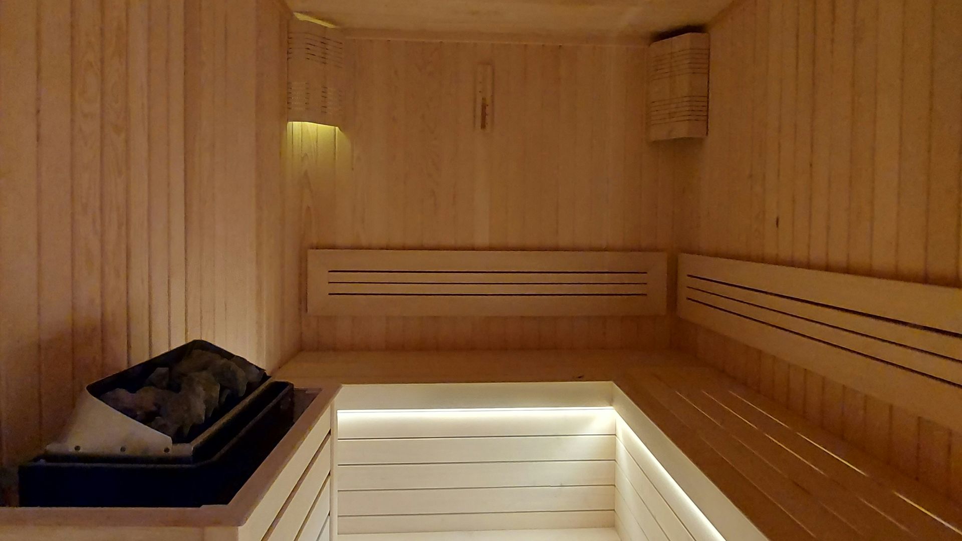 a wooden room with a bench and a light