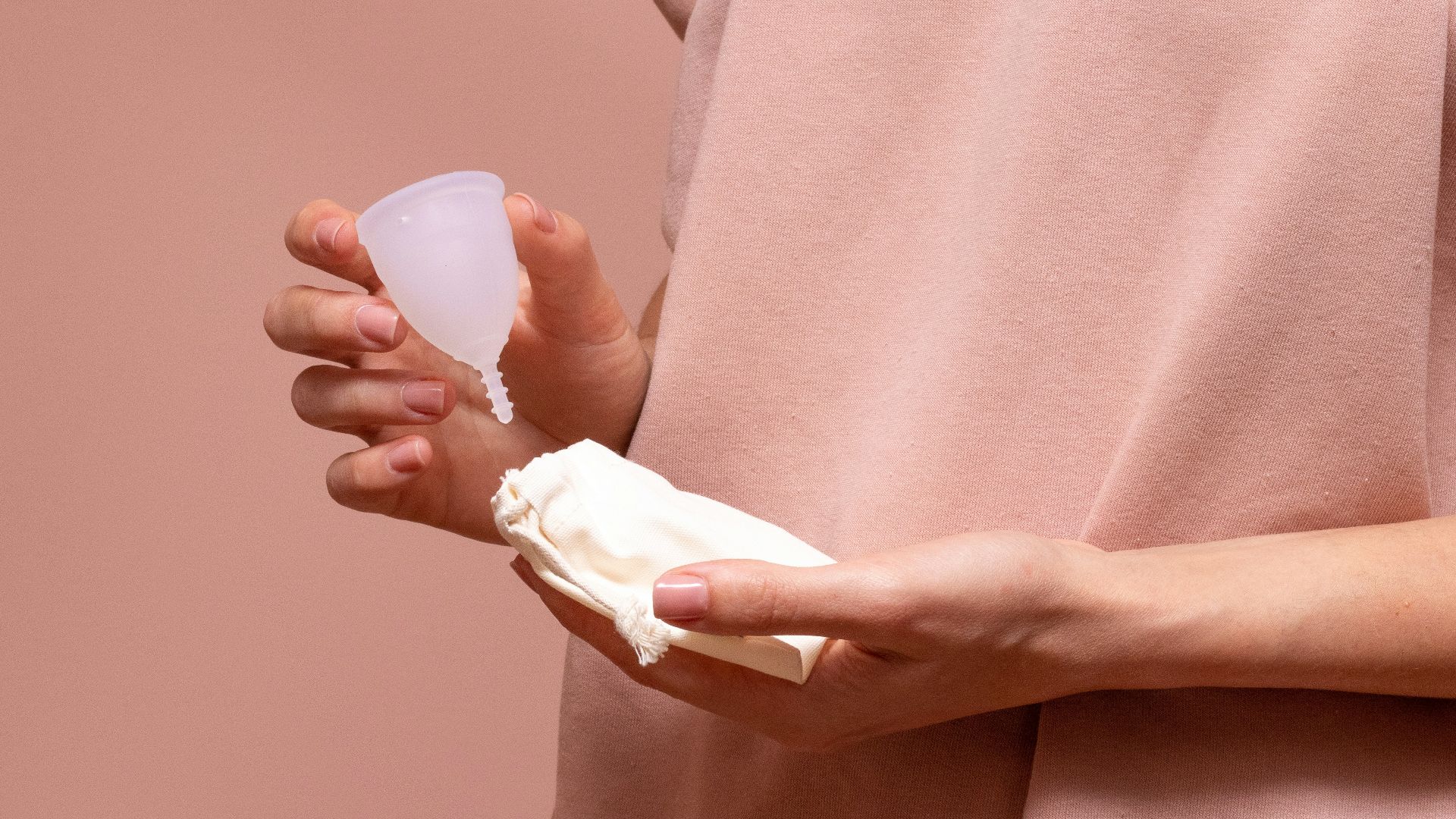 person in pink long sleeve shirt holding white heart ornament