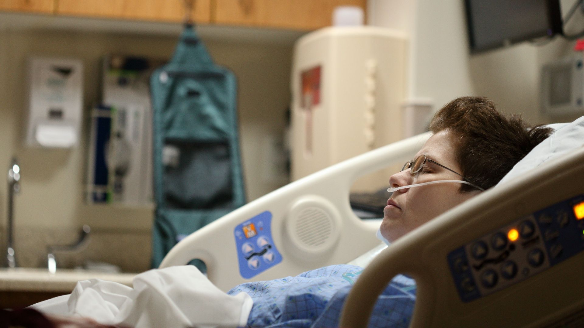 boy lying on beige recliner hospital bed