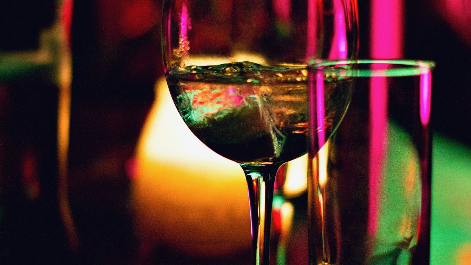 half filled wine glass beside half empty clear pint glass