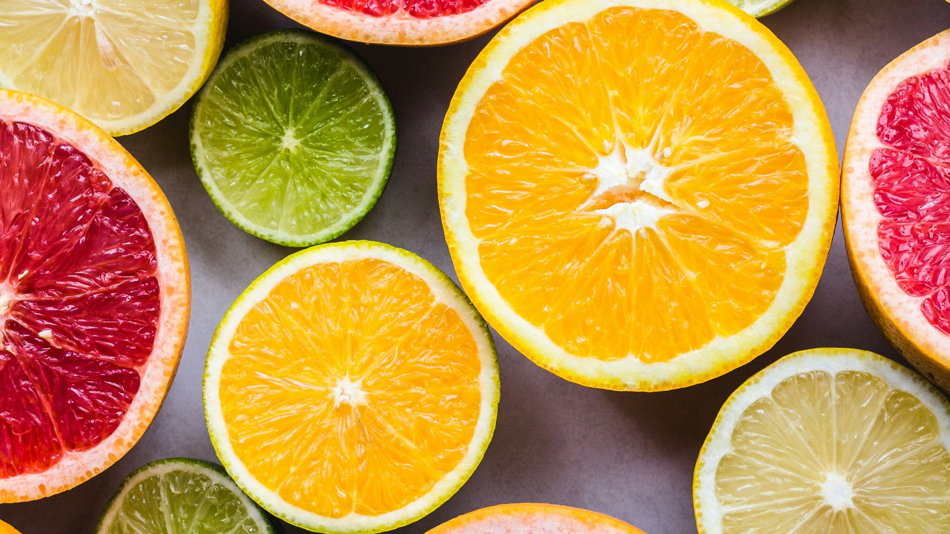 flat lay photography of sliced pomegranate, lime, and lemon