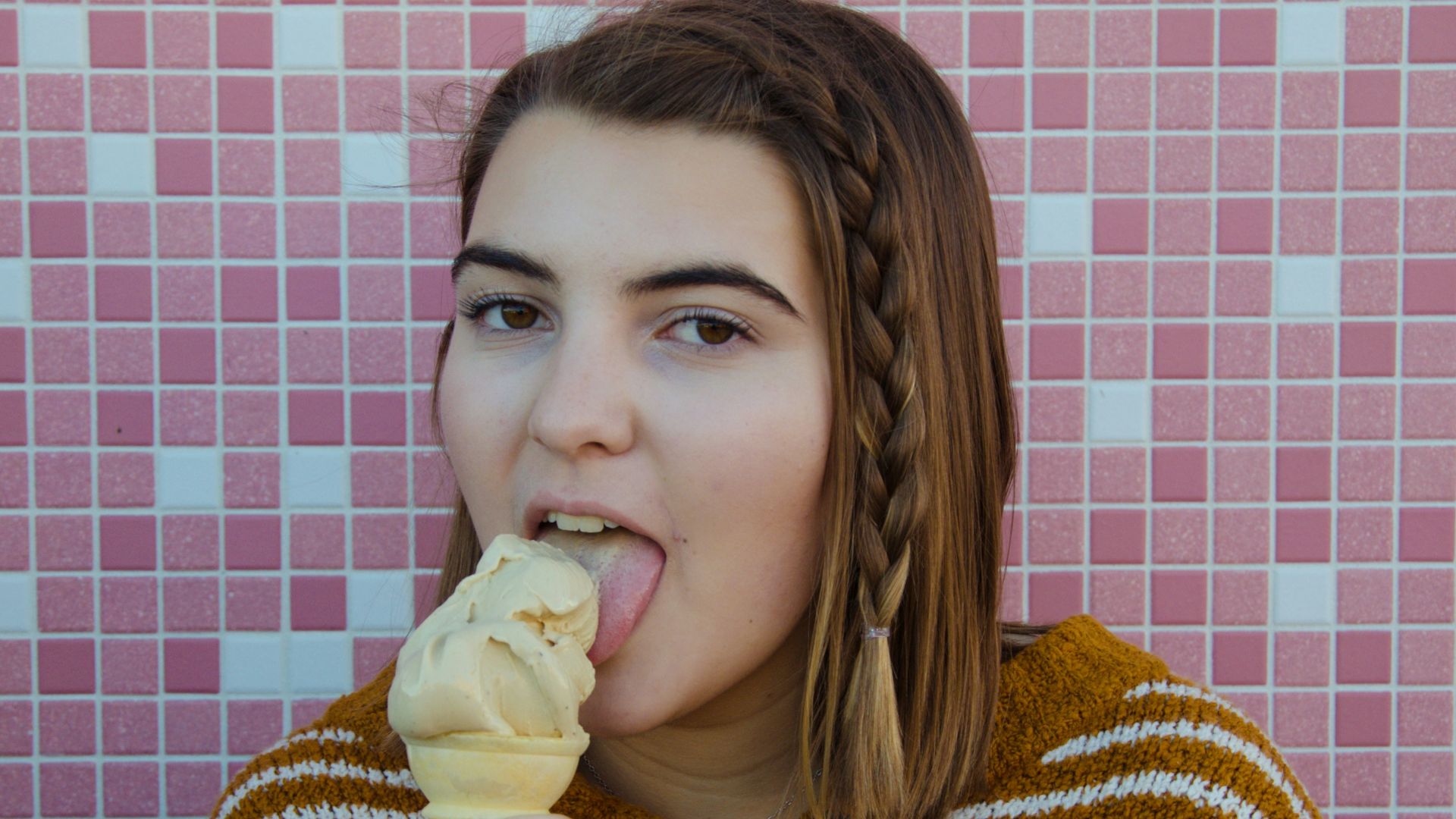 woman wearing brown and white floral sweater eating ice cream