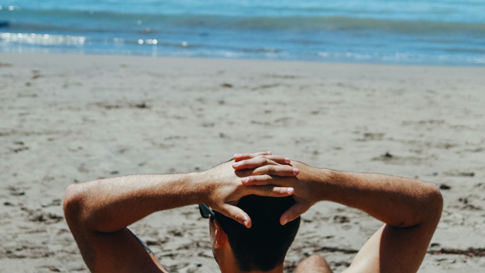 man leaning on beach