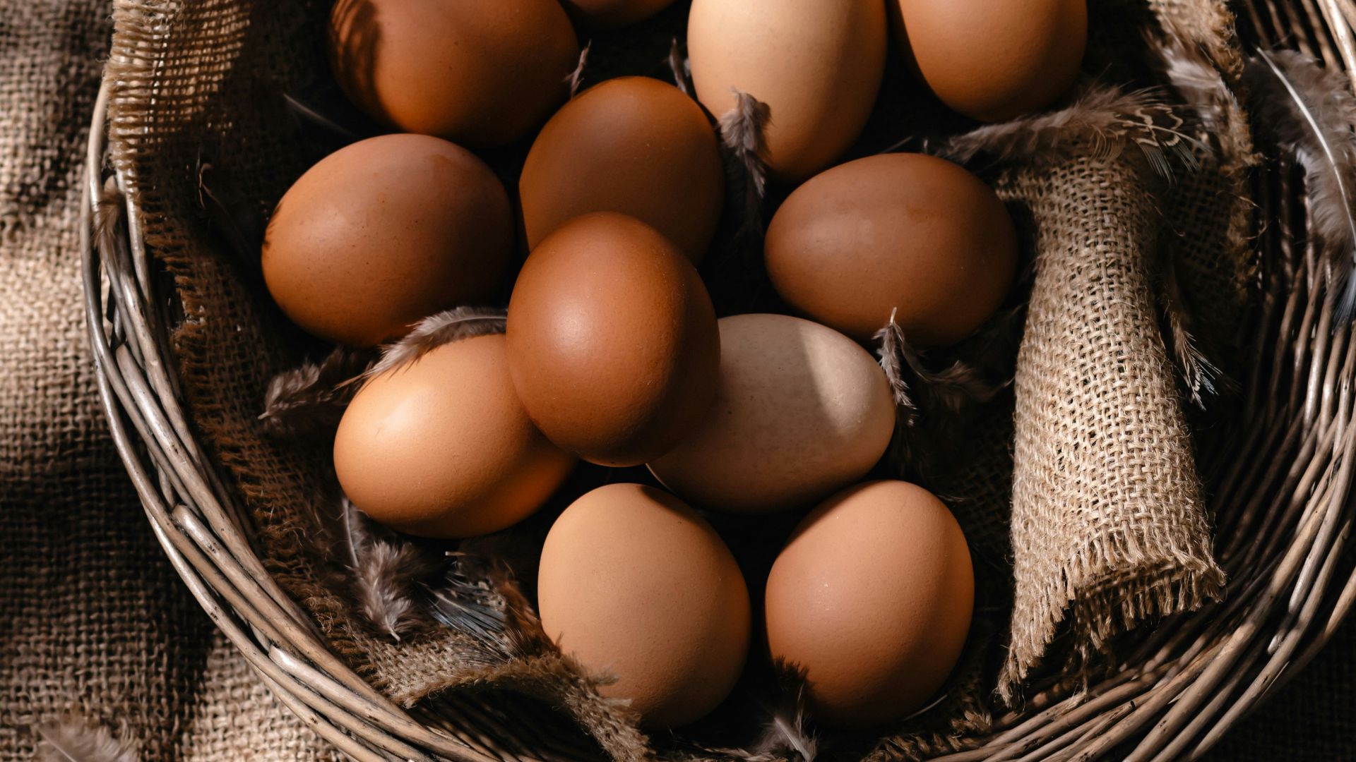 a basket filled with brown eggs on top of a table
