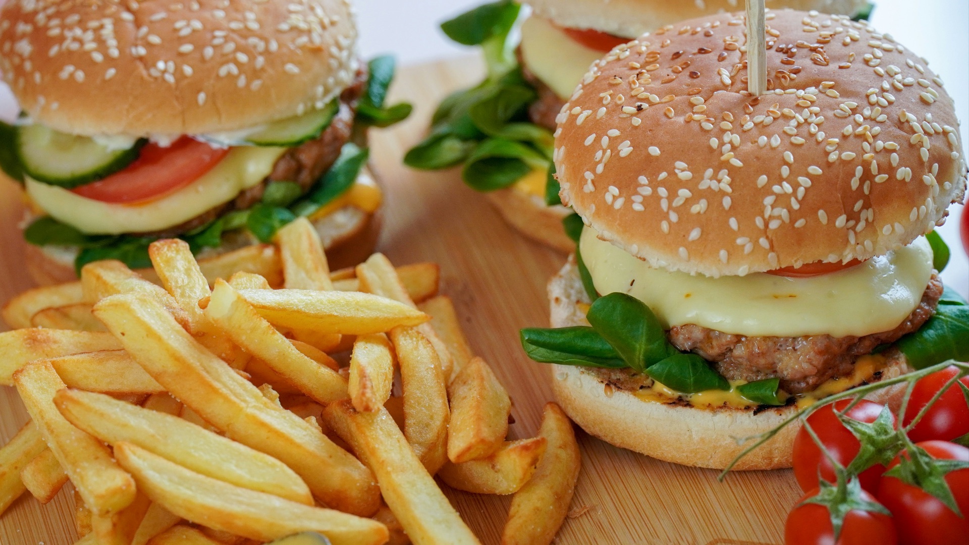 burger with lettuce and fries on brown wooden table