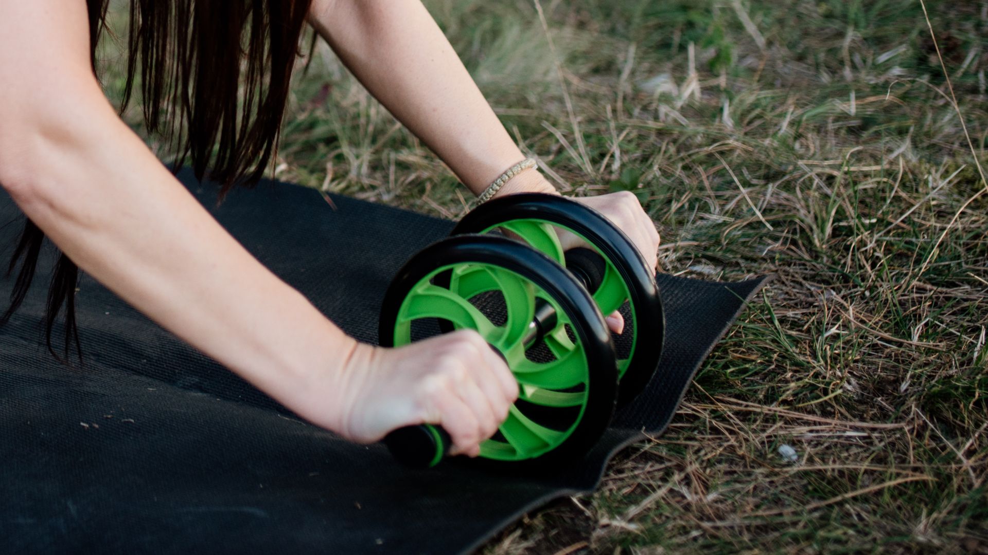 File:Woman doing exercises with an ab wheel and ankle weights on a yoga mat in the park. (51540571665).jpg