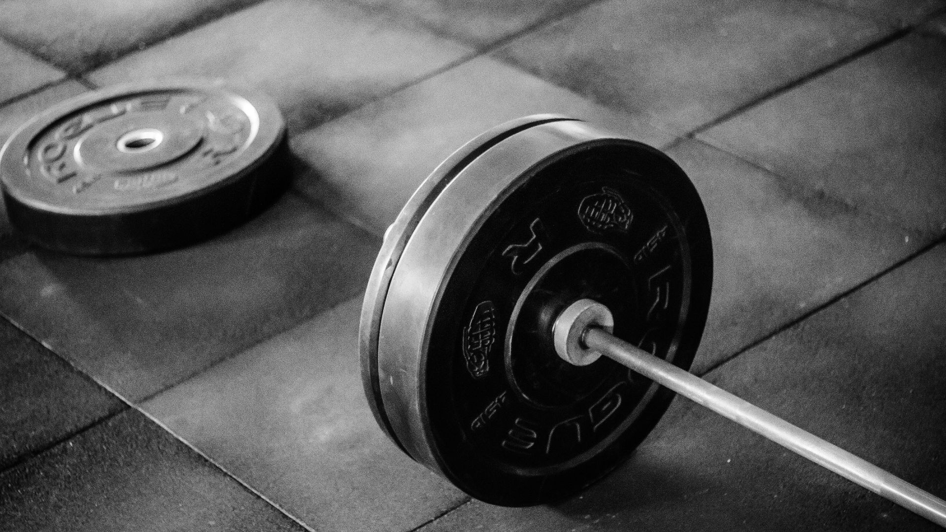 black barbell on tile flooring