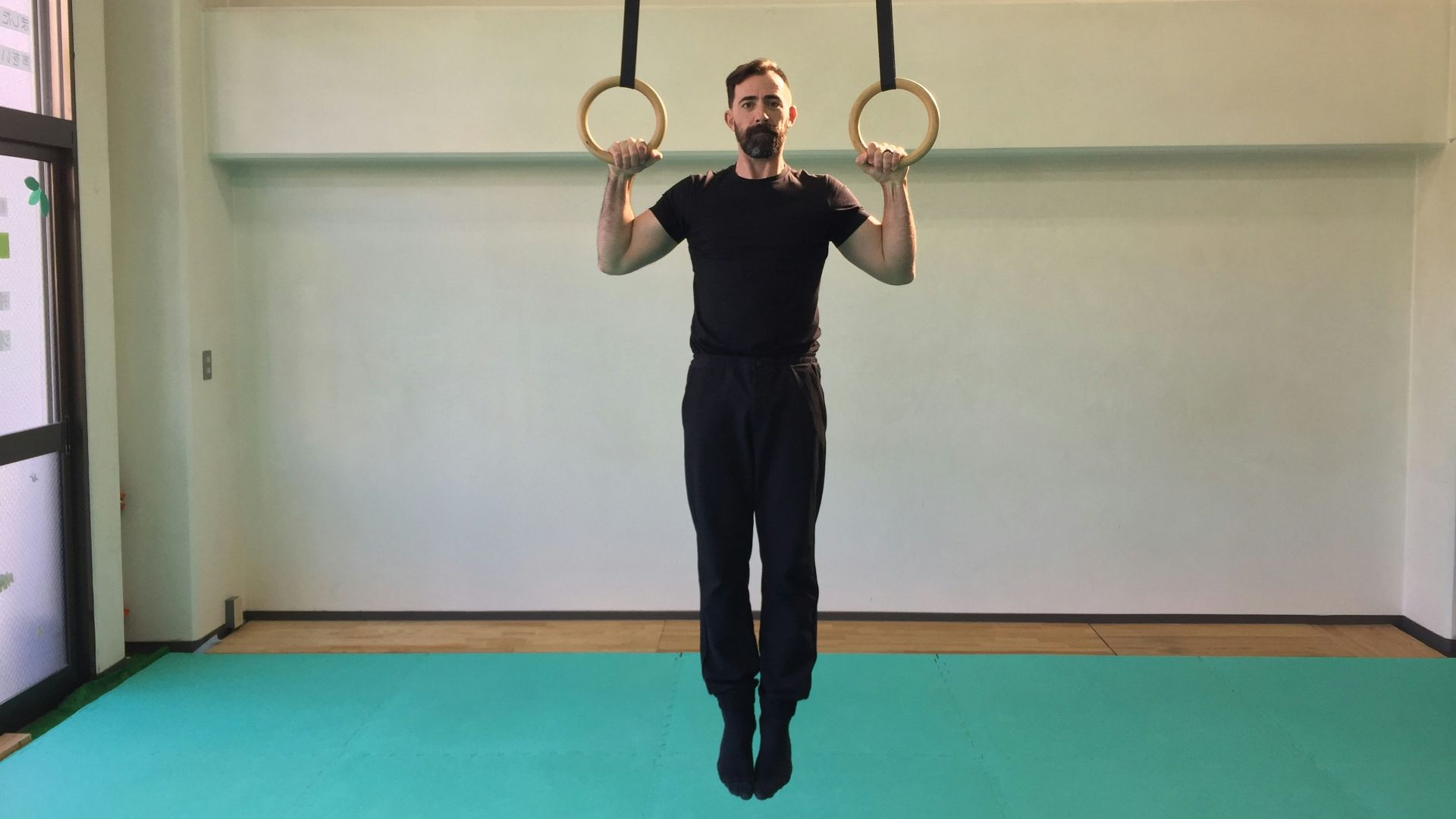 a man is doing a pull up exercise with two rings