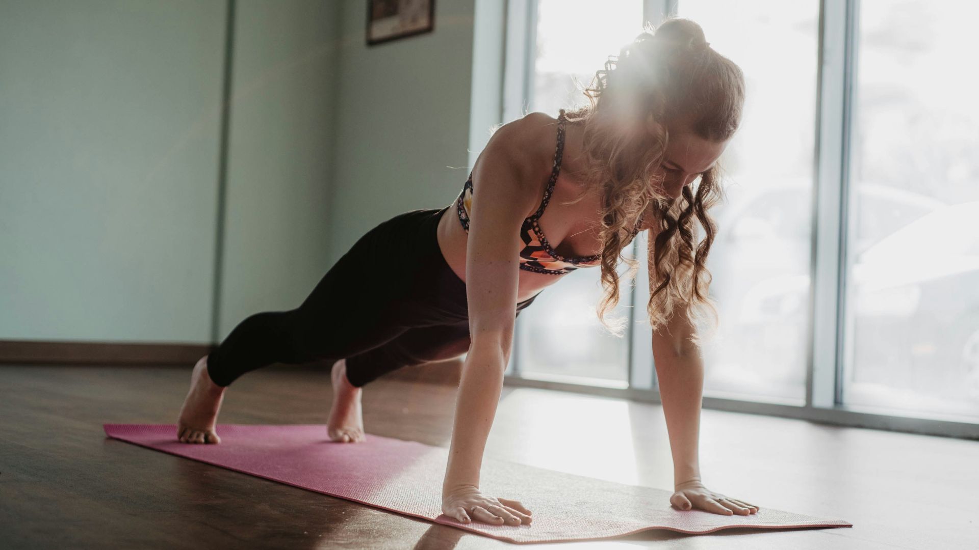 woman in black tank top and black leggings doing yoga