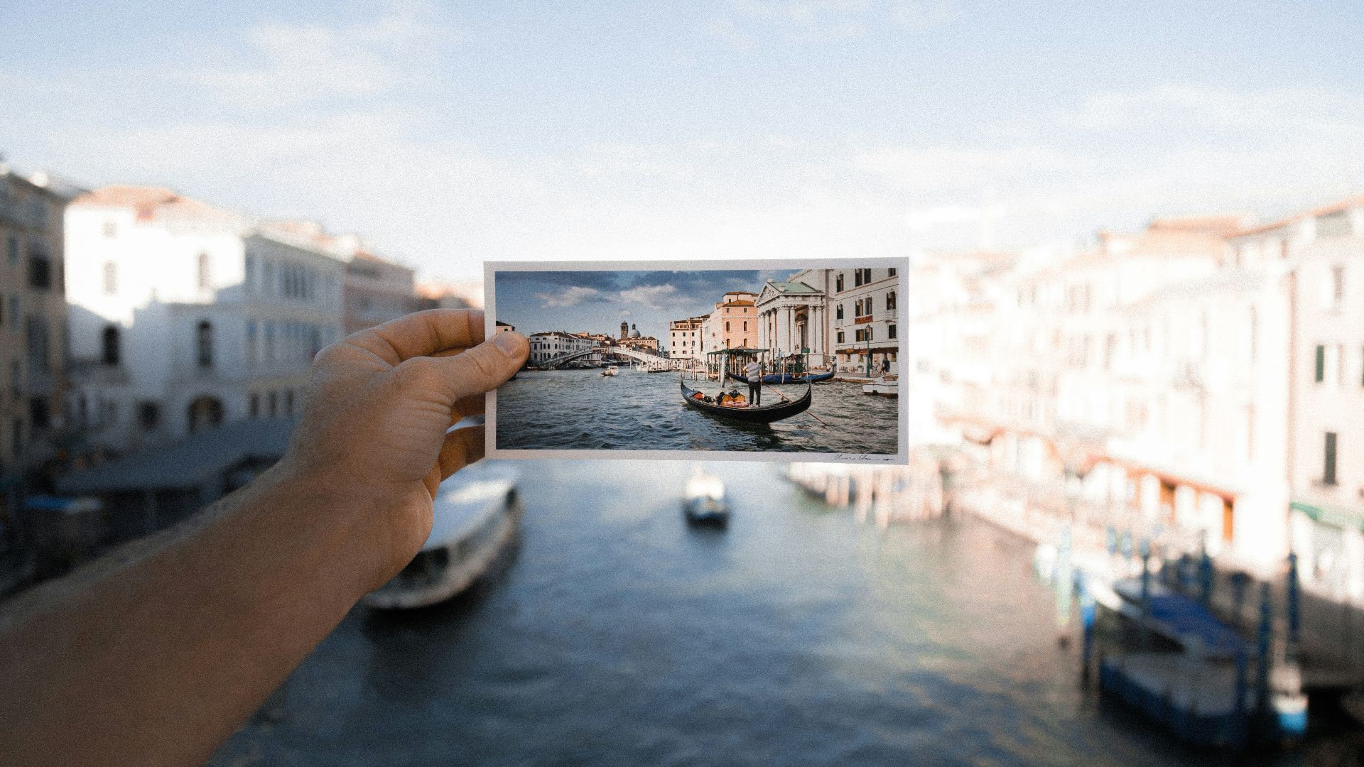 person holding photo of boat on body of water