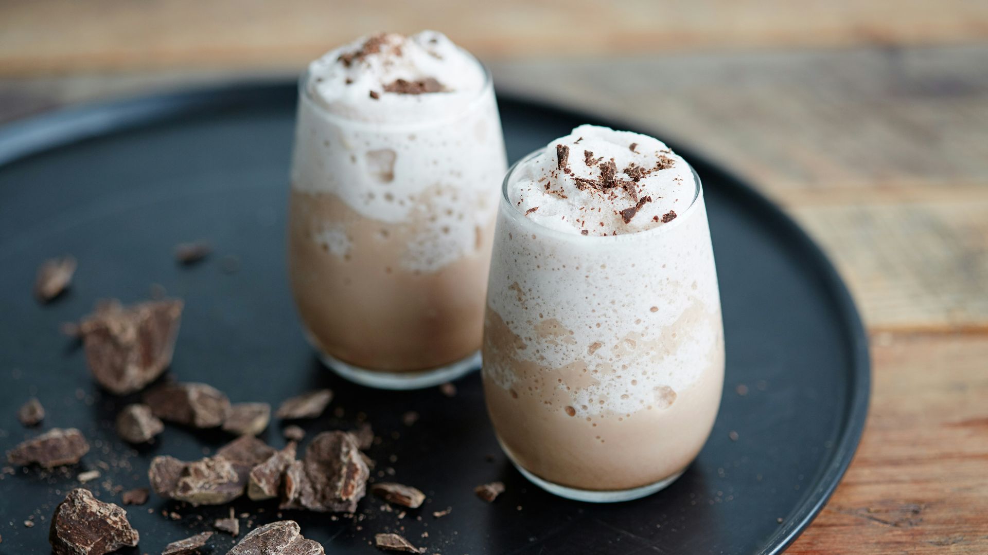 clear drinking glass with white liquid on black wooden table