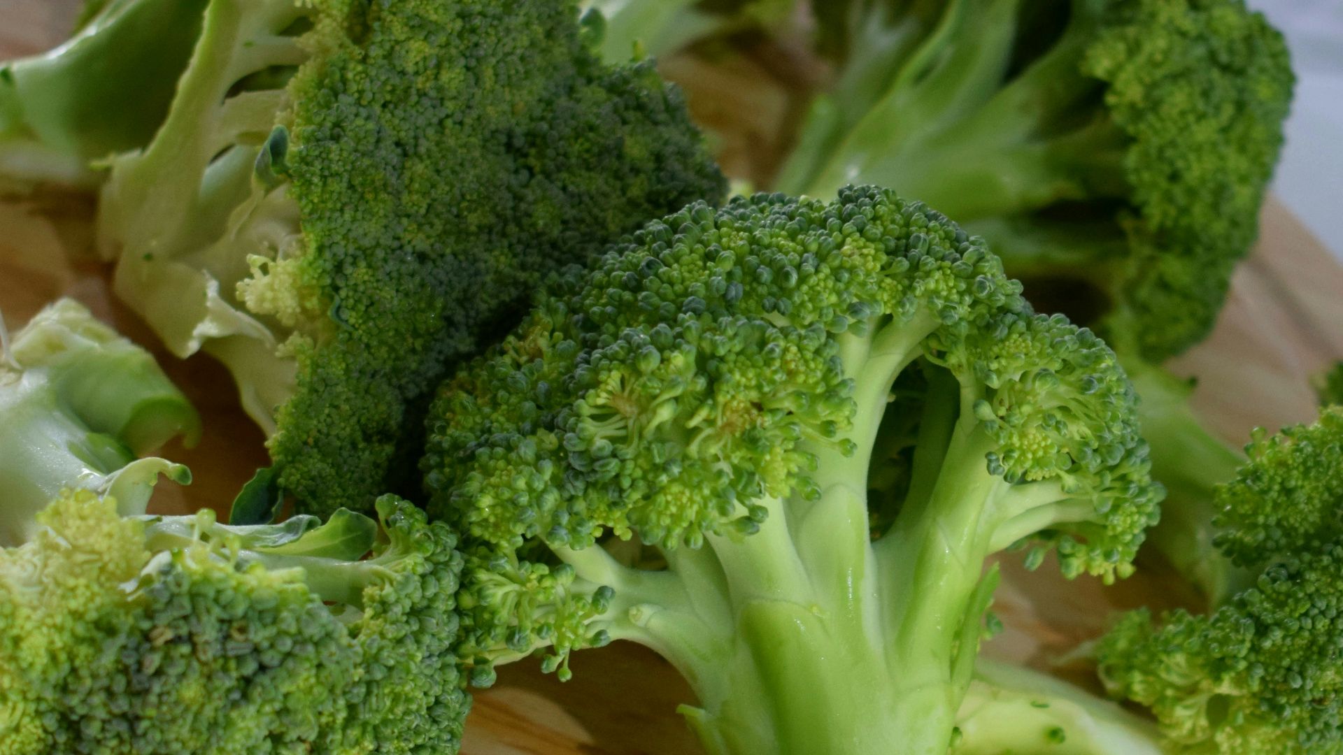 green broccoli on brown wooden round plate