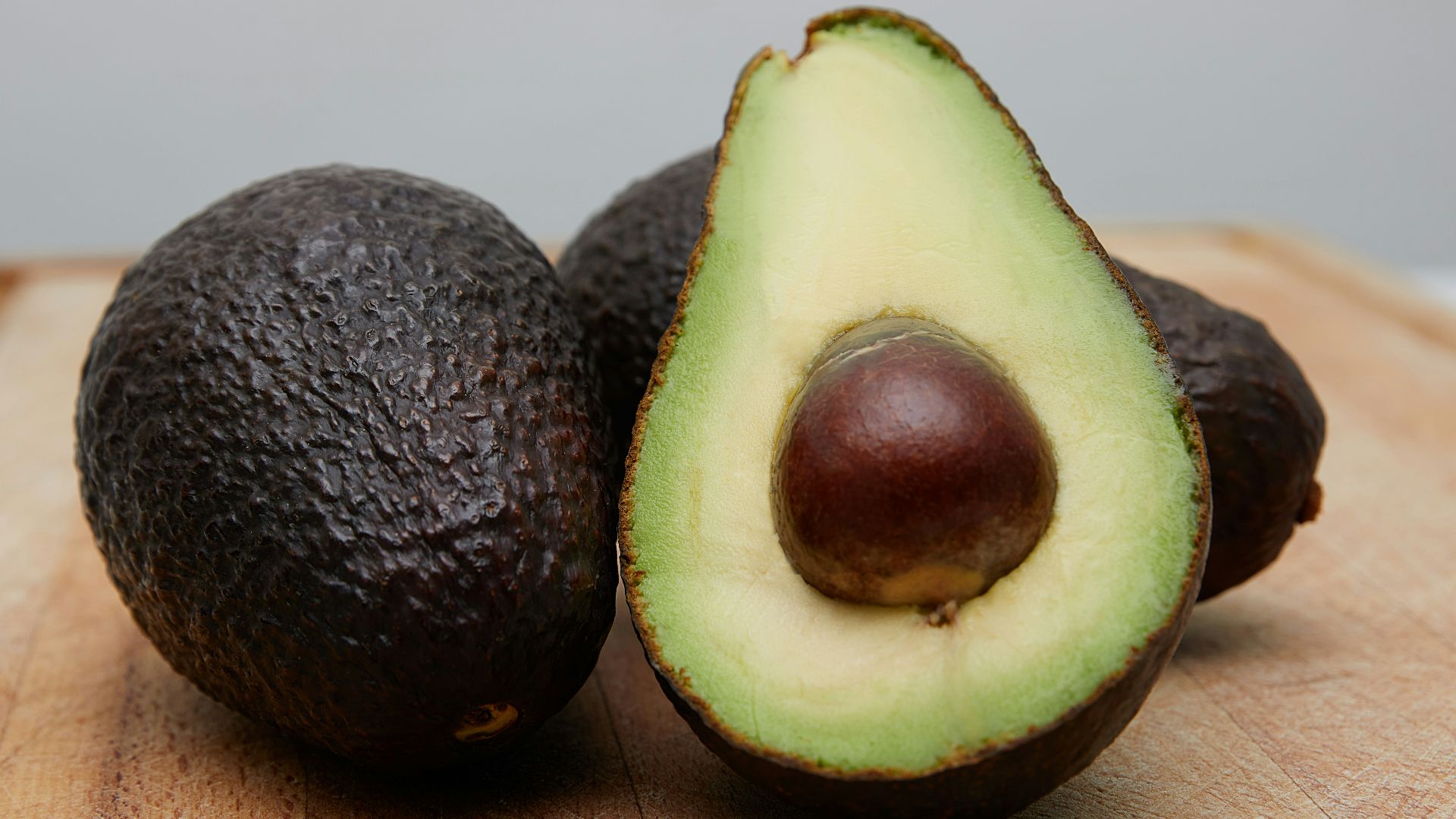 sliced avocado fruit on brown wooden table