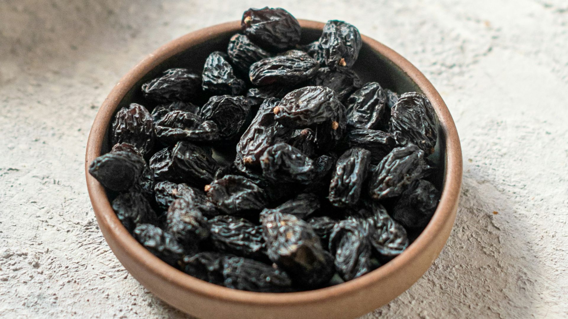 brown and black coffee beans on white ceramic bowl