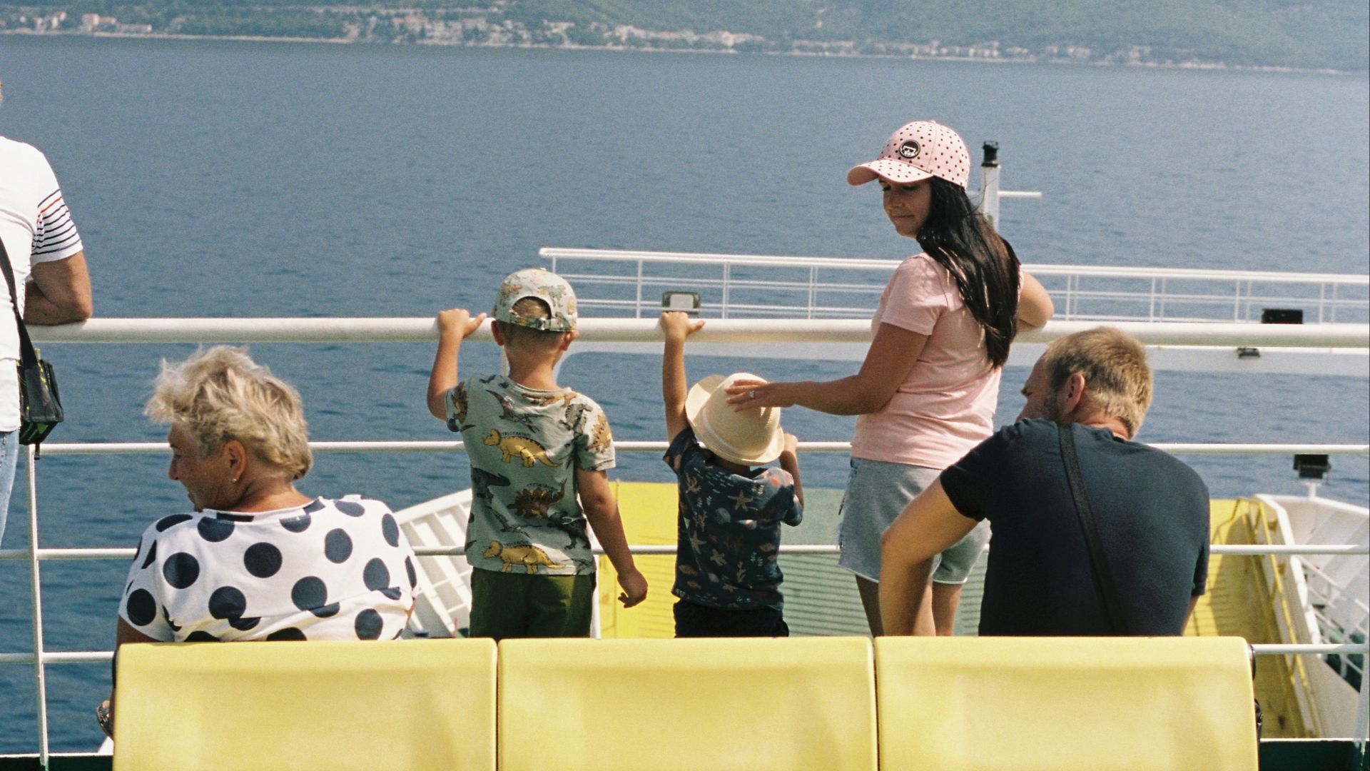 a group of people sitting on a yellow bench