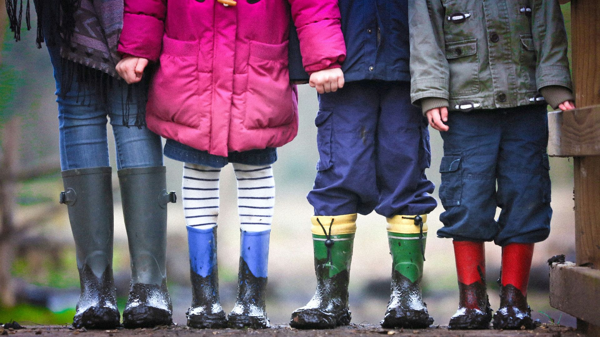 four children standing on dirt during daytime