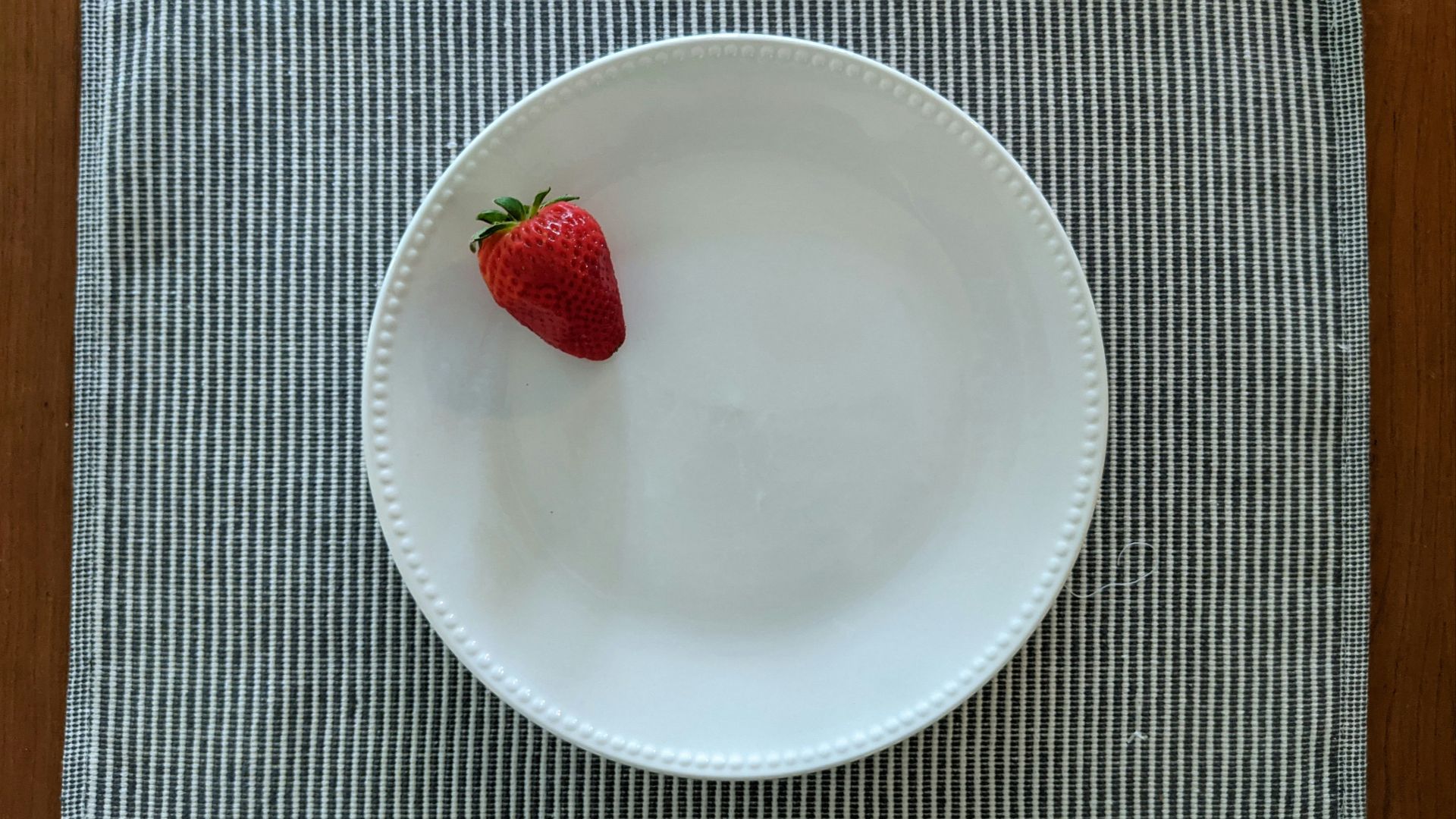 red strawberry on white ceramic plate