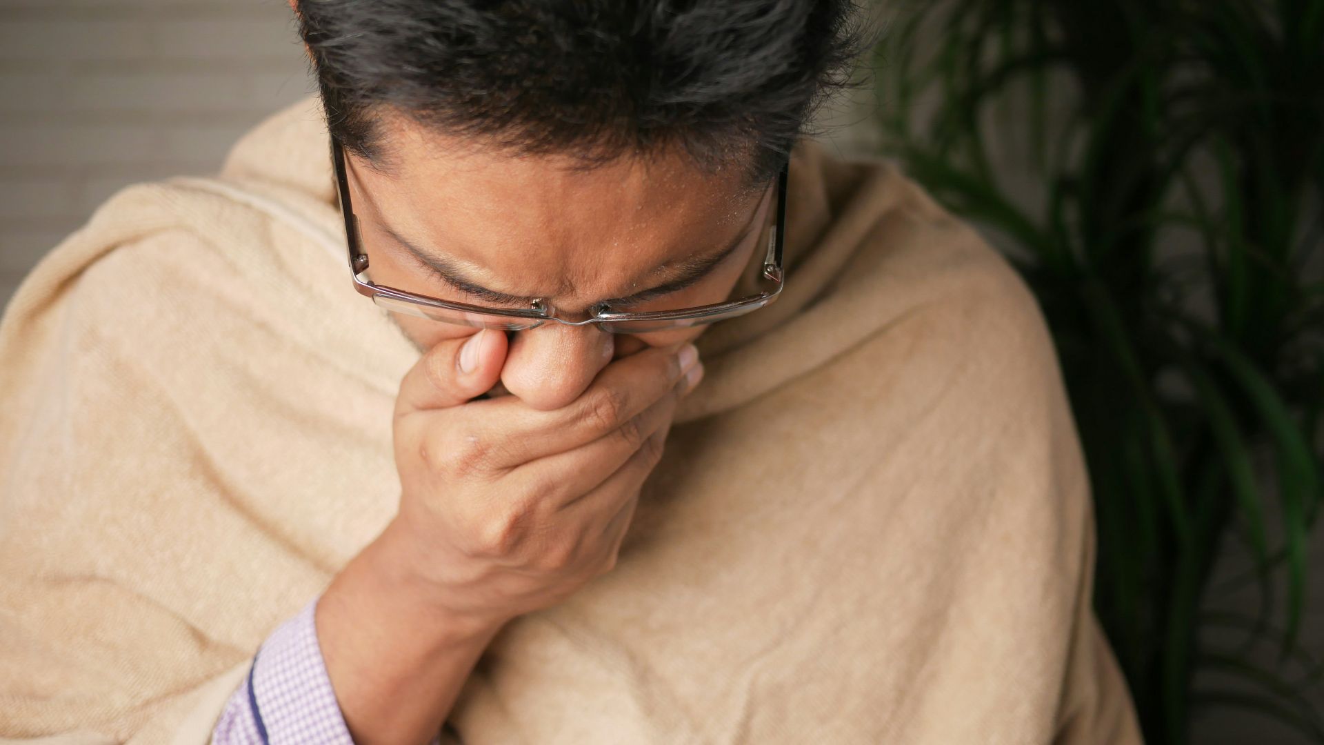 man in brown sweater wearing black framed eyeglasses
