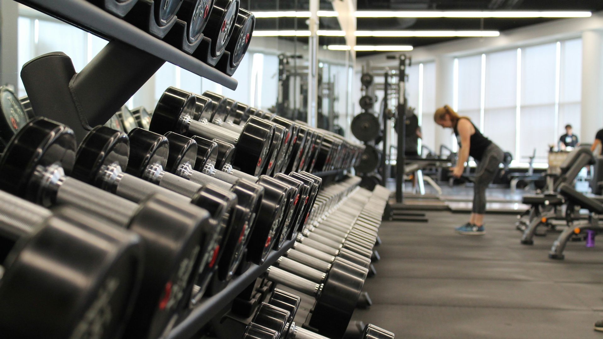 woman standing surrounded by exercise equipment