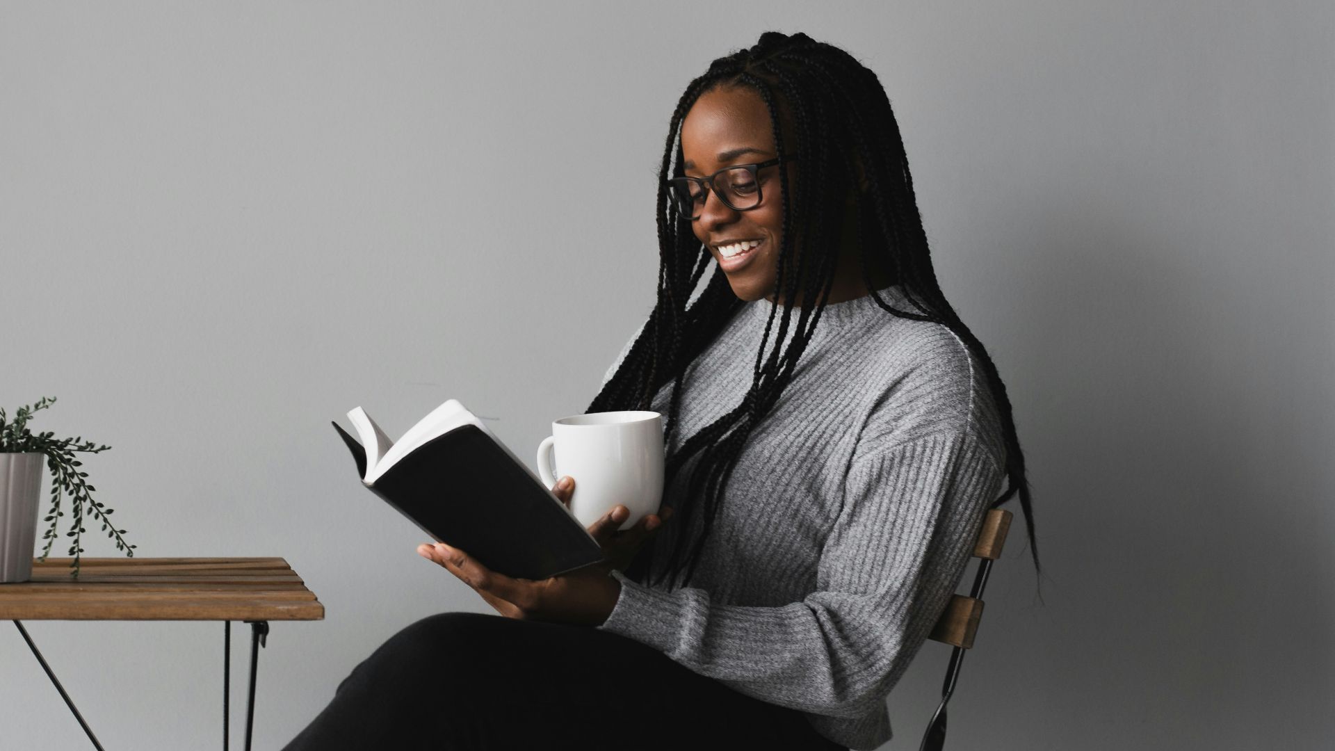 woman in white and black stripe long sleeve shirt sitting on chair