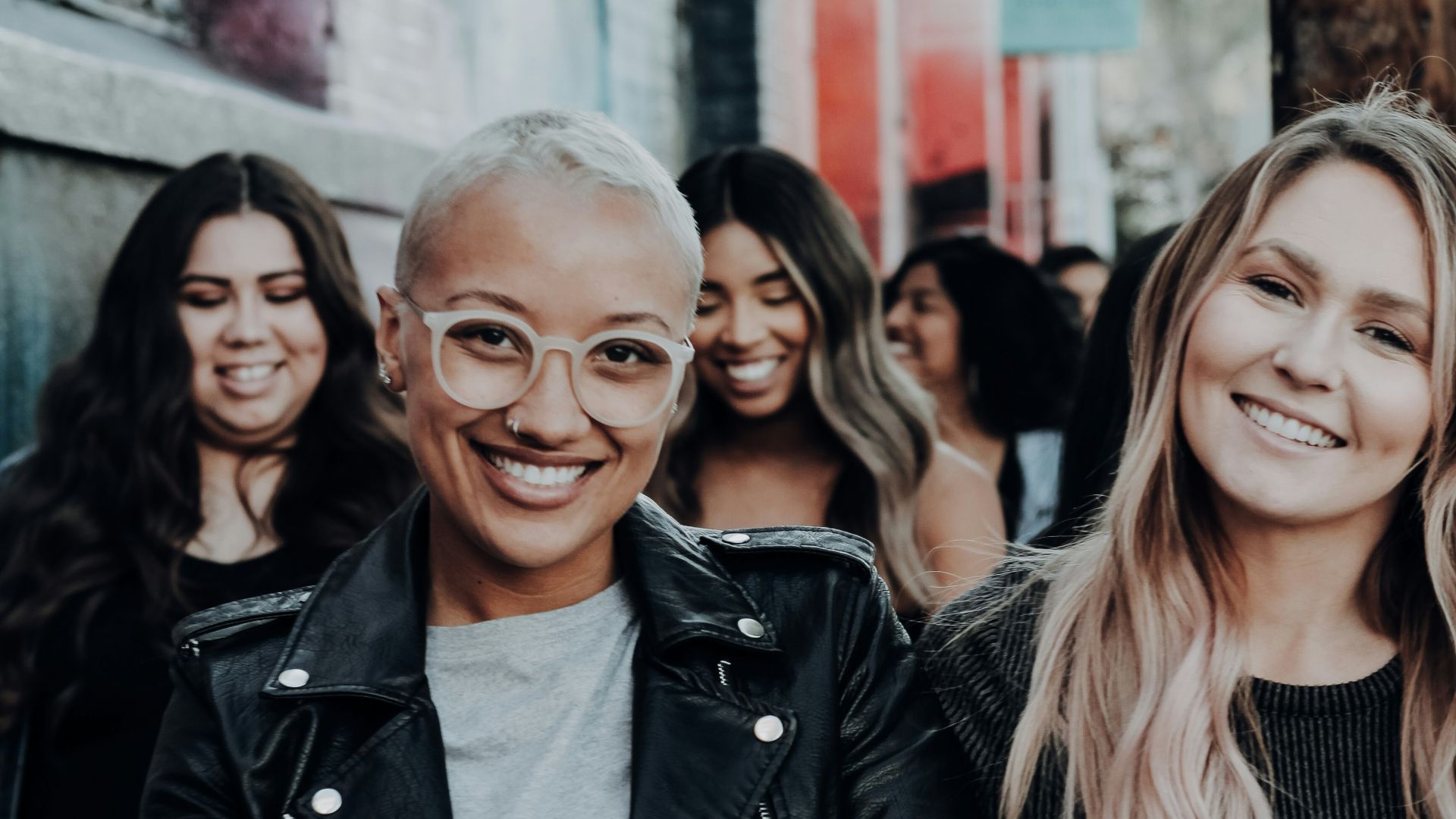 man in black leather jacket beside woman in black and white stripe shirt