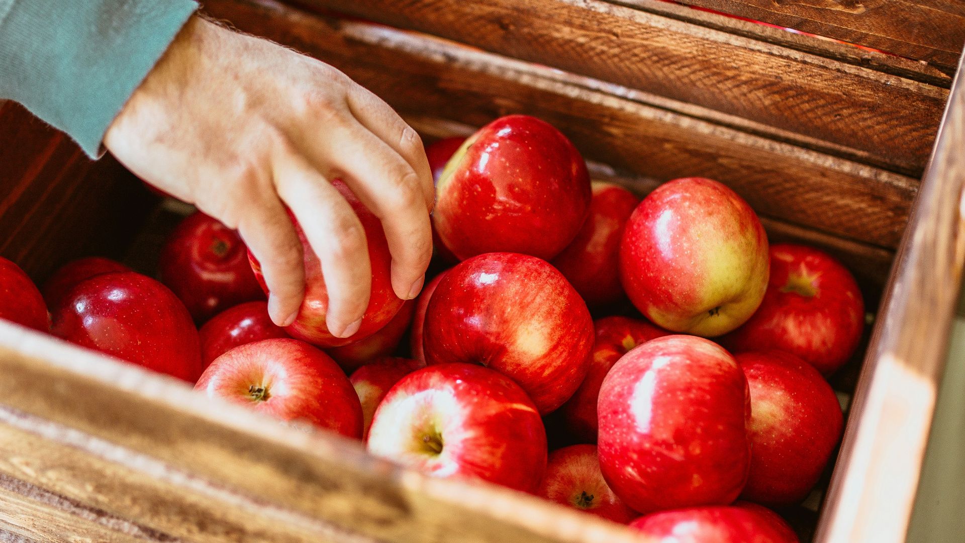 red fruits in brown wooden crate