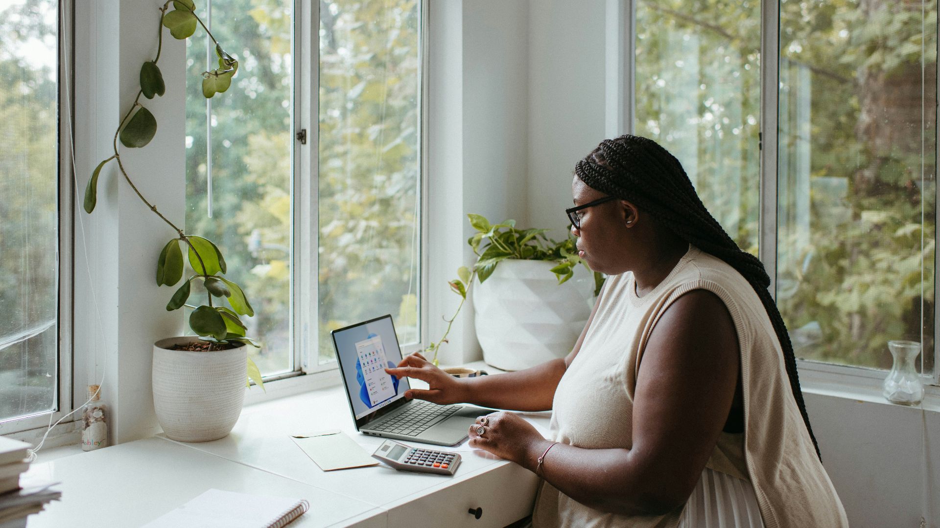a woman sitting at a table with a laptop