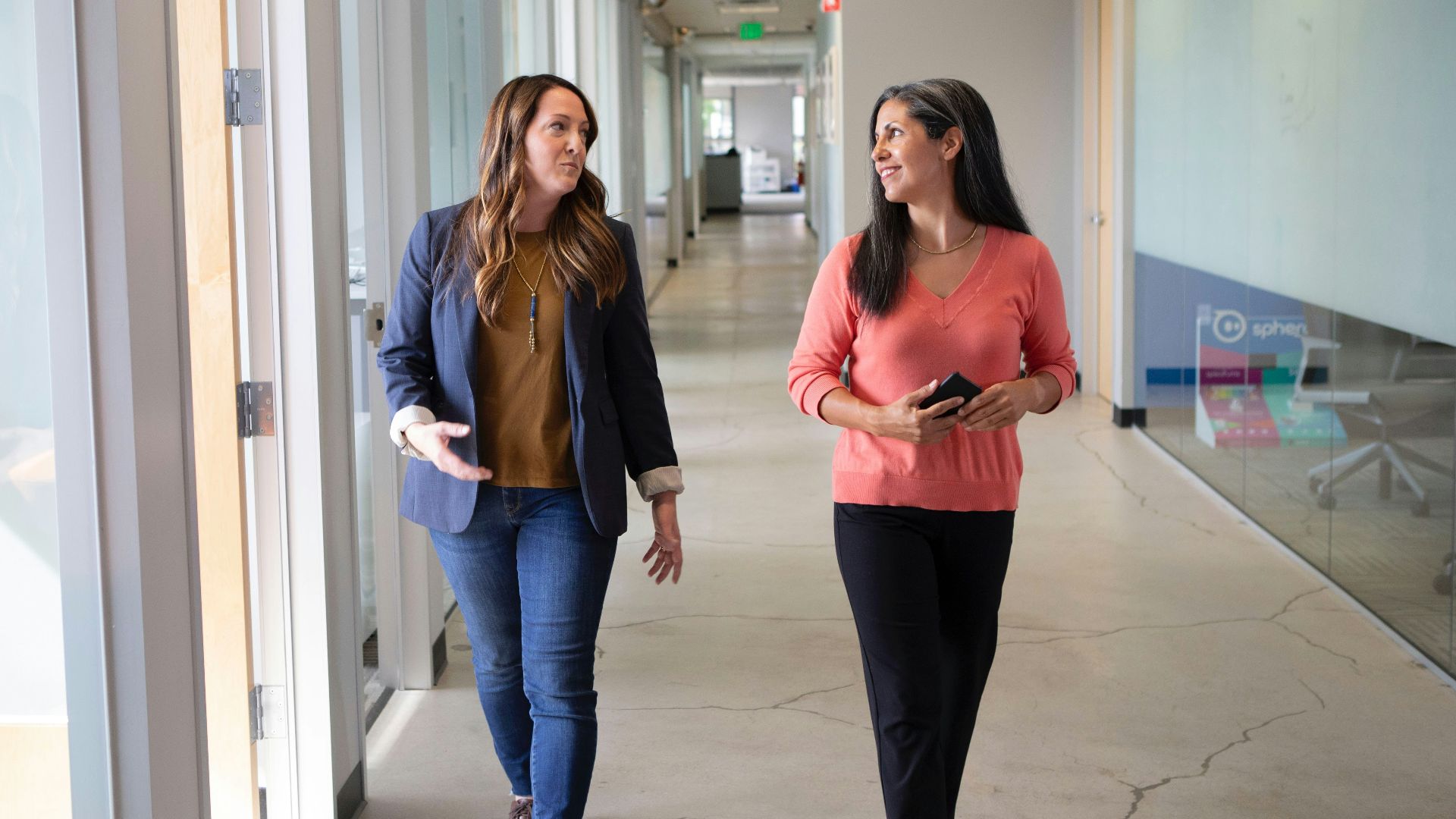 2 women standing near white wall
