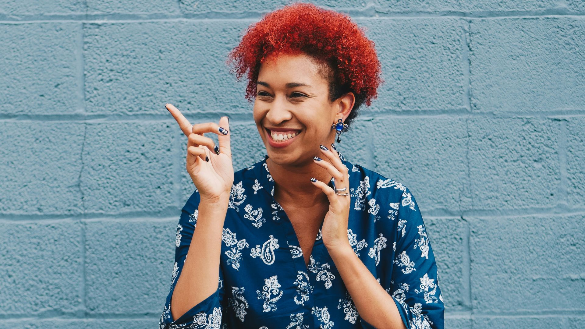 woman smiling while pointing on her right side