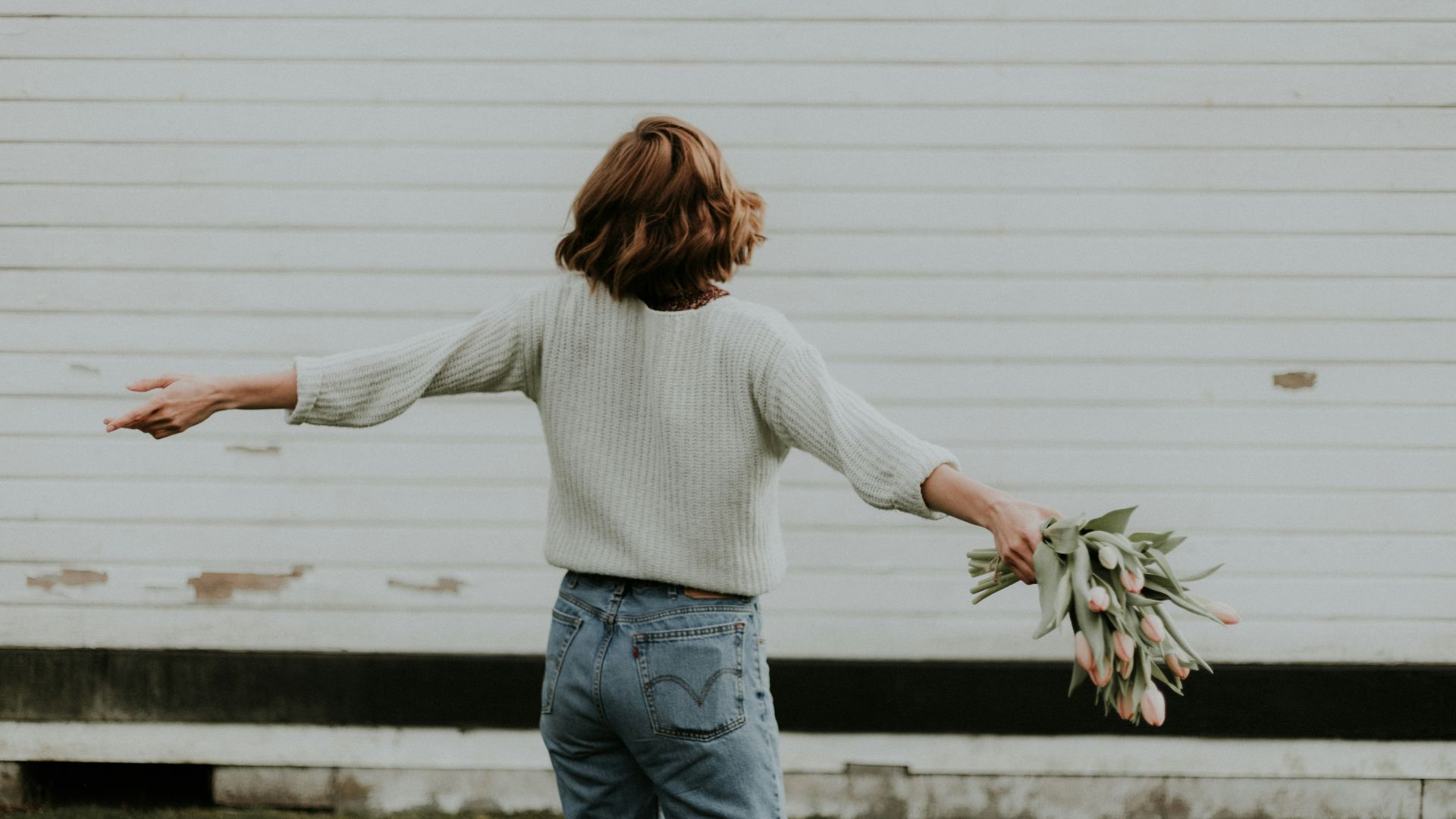 woman holding pink petaled flower