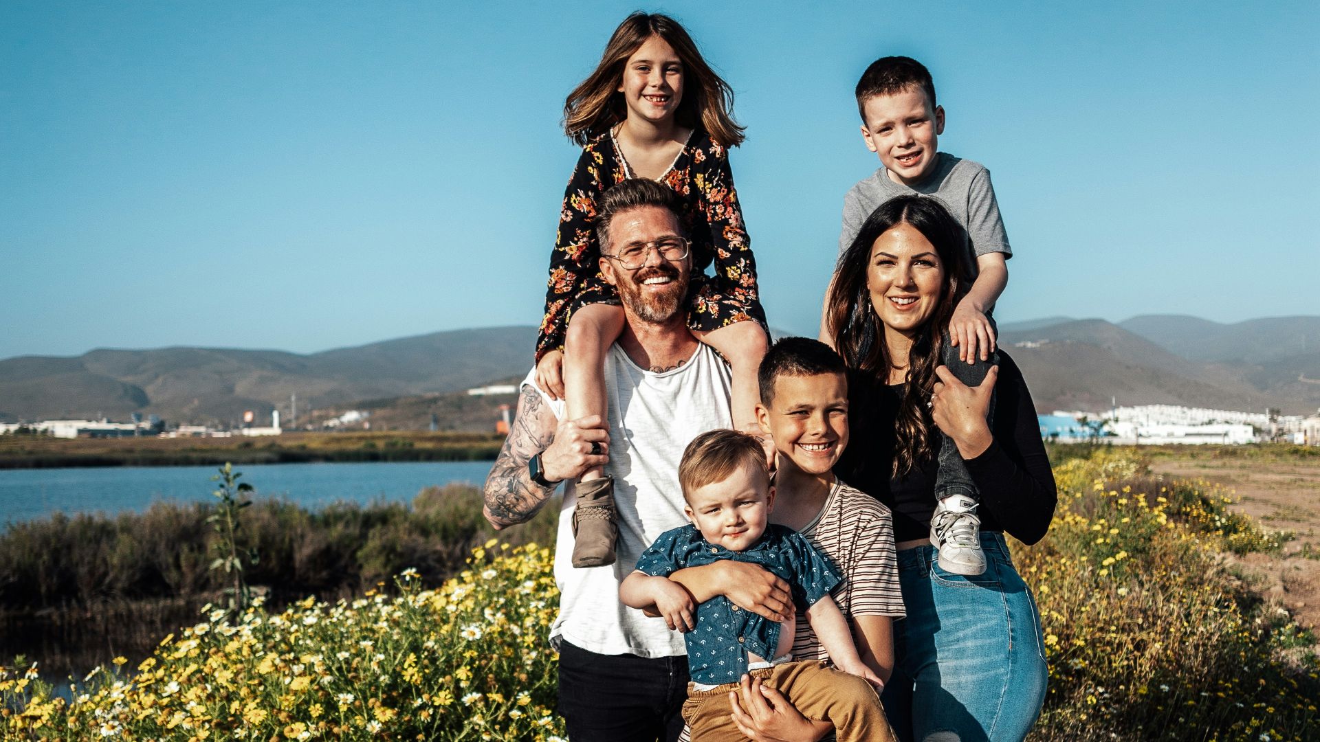 2 women and man standing on green grass field during daytime
