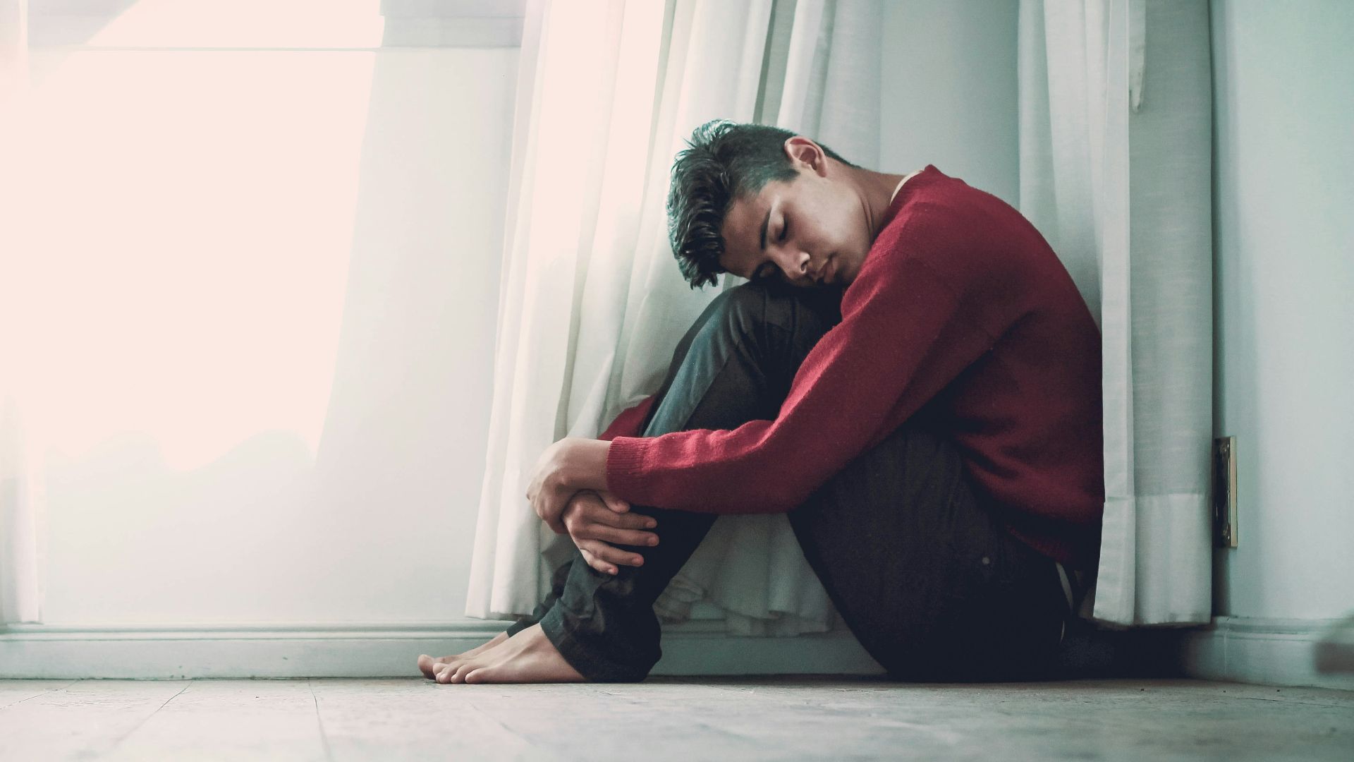 man beside white frame window