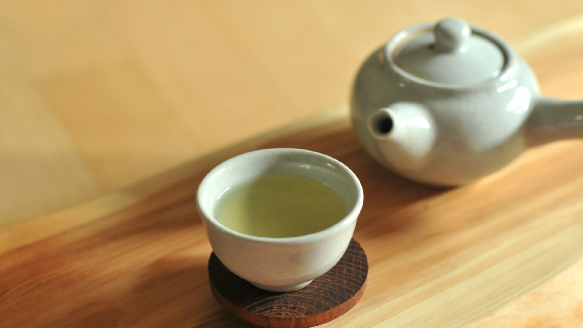 white ceramic teacup on brown wooden table