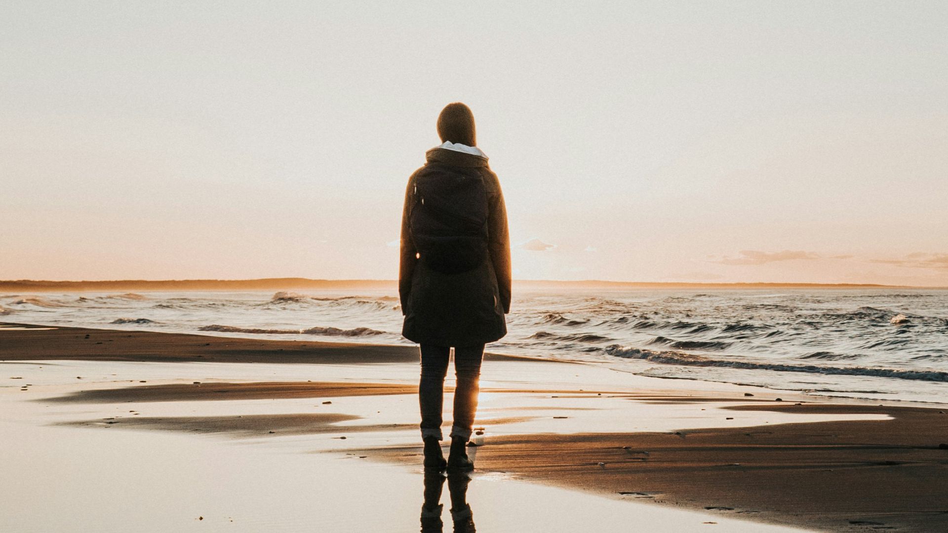 woman standing on sands near shoreline