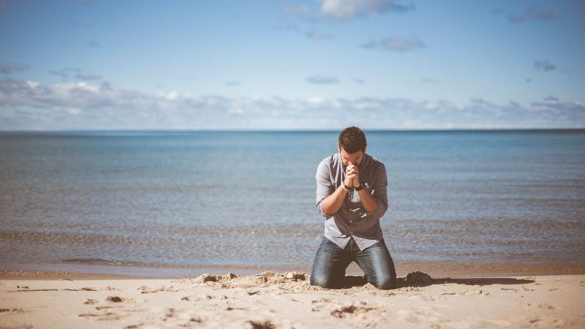man kneeling down near shore