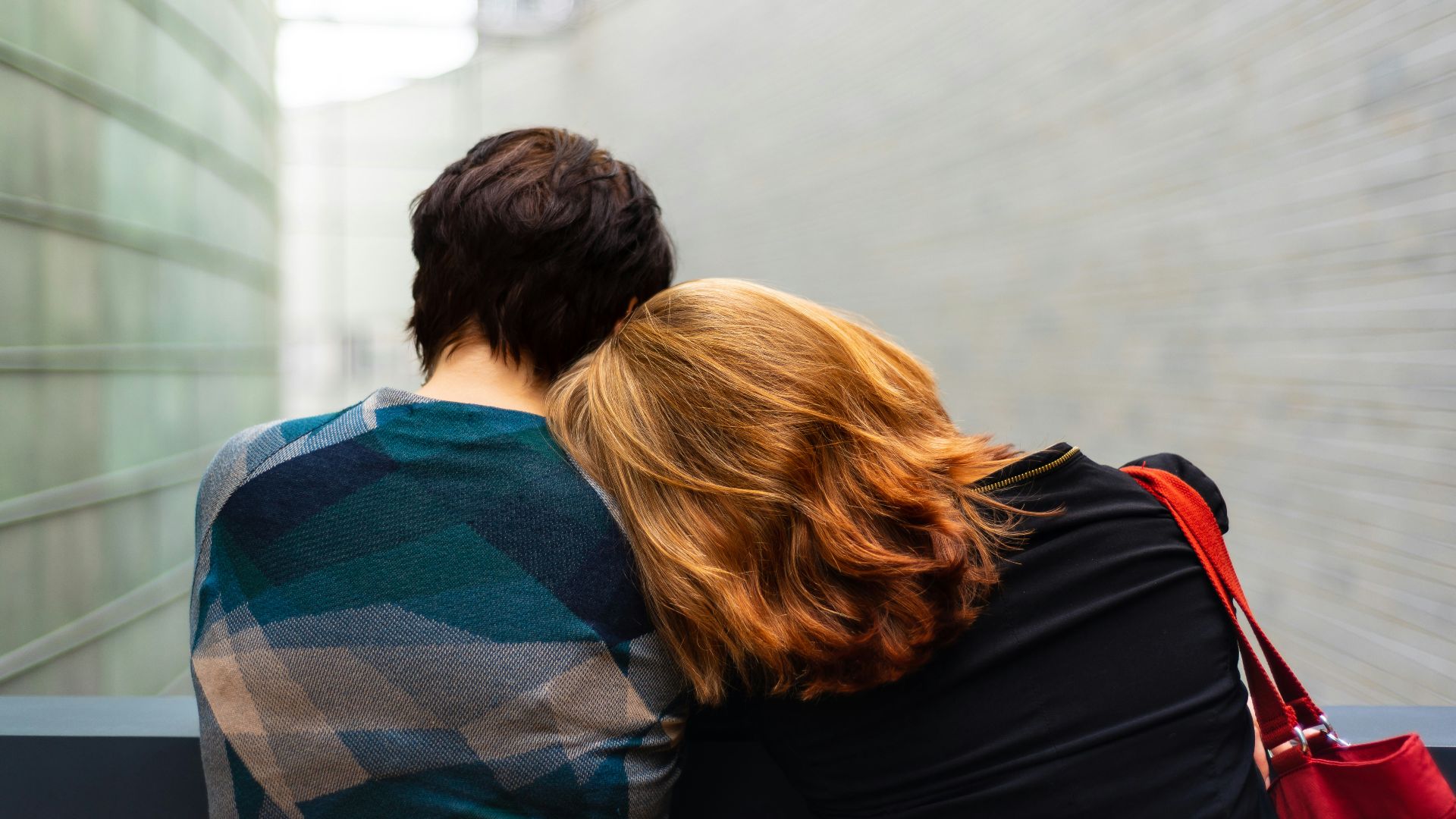 a woman rests her head on another person's shoulder