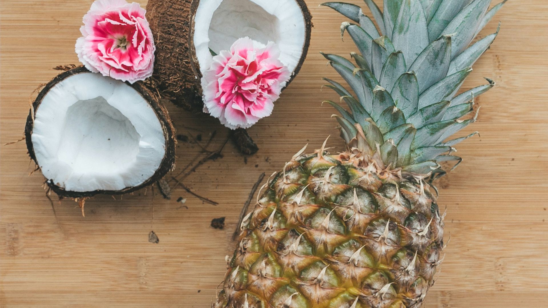 pineapple fruit beside coconut on top of chopping board