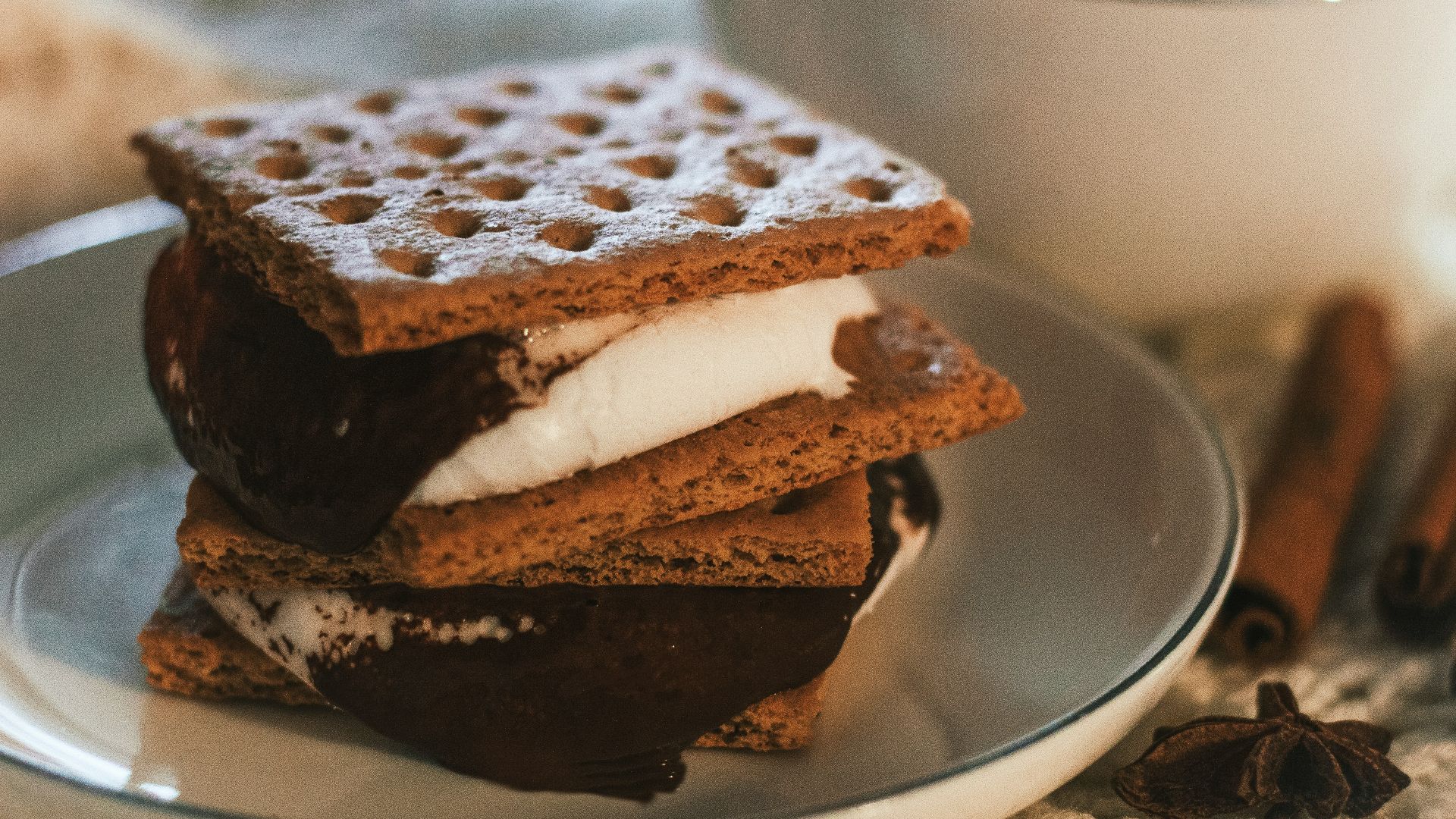 a stack of waffle sandwiches on a plate next to a cup of coffee