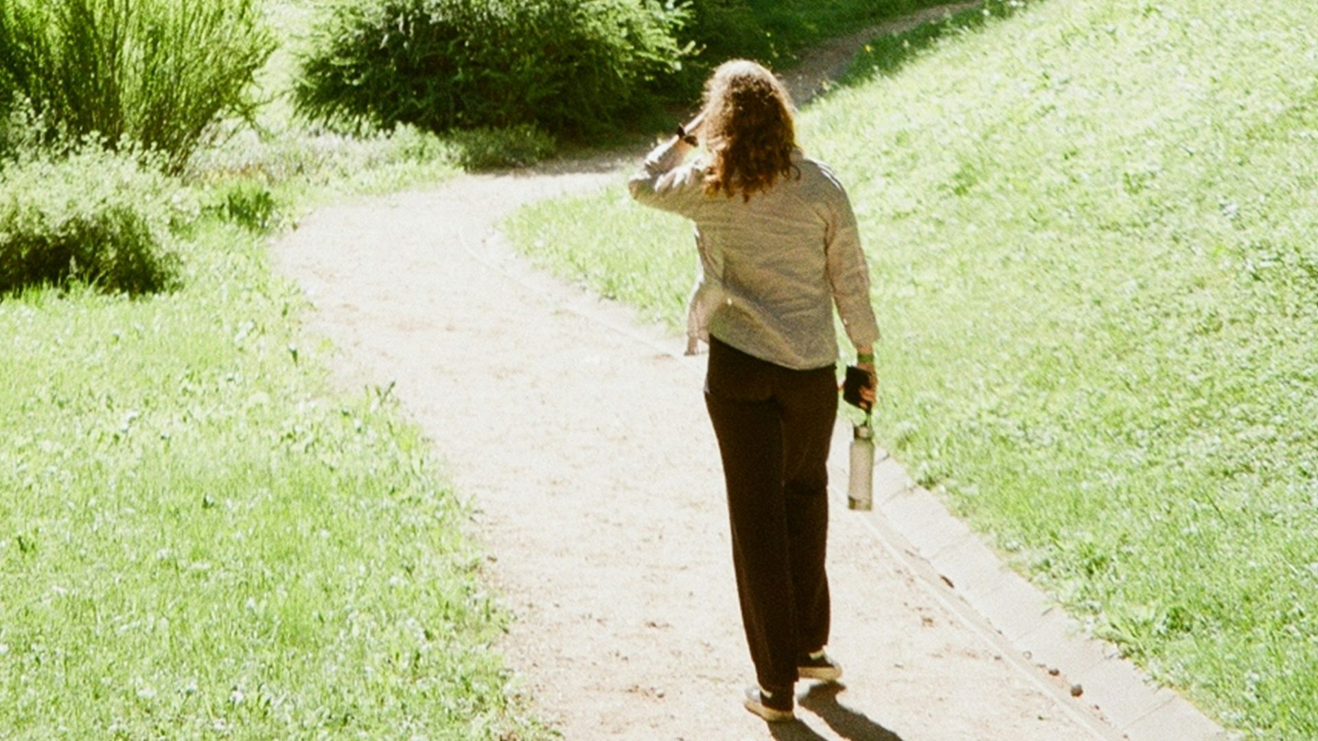 A woman walking down a path in a park