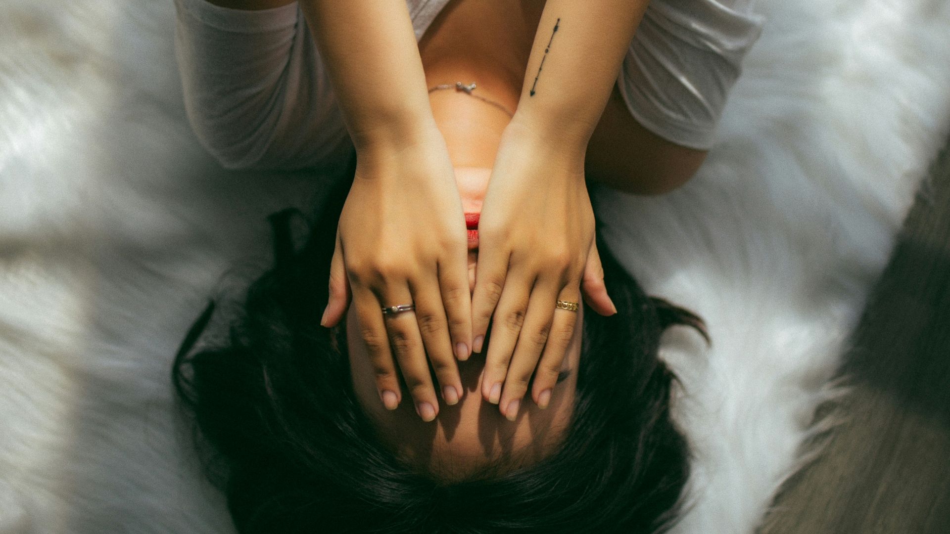 a woman holds her hands over her face