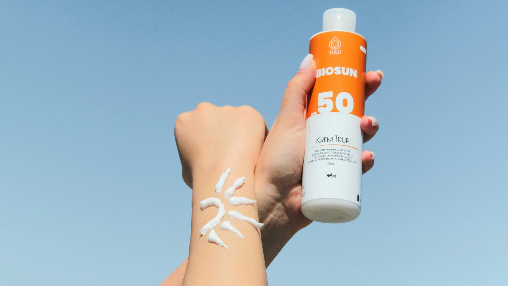 a person holding a bottle of sunscreen in their hand