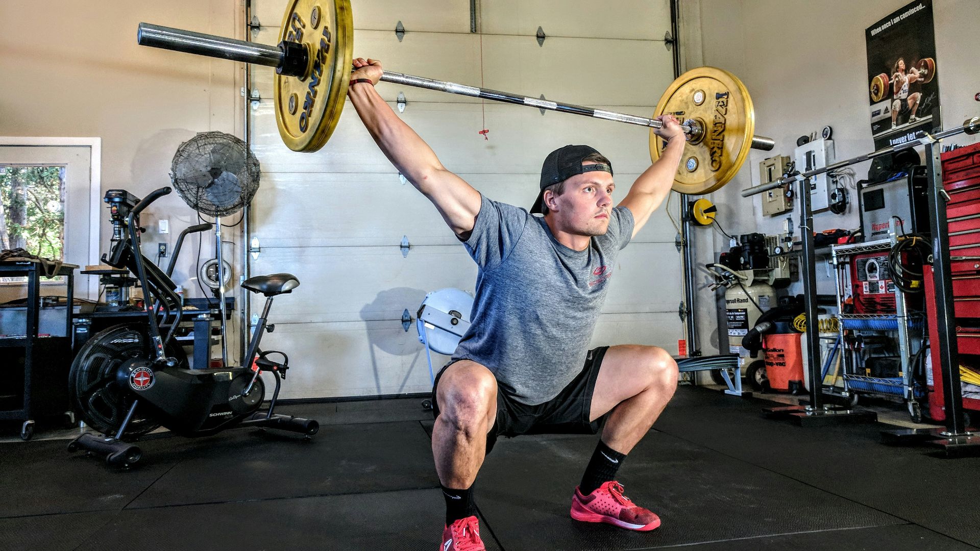 man lifting yellow barbell