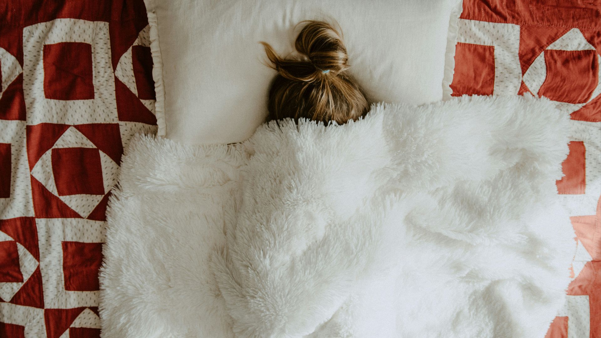 white fur textile on red and white textile