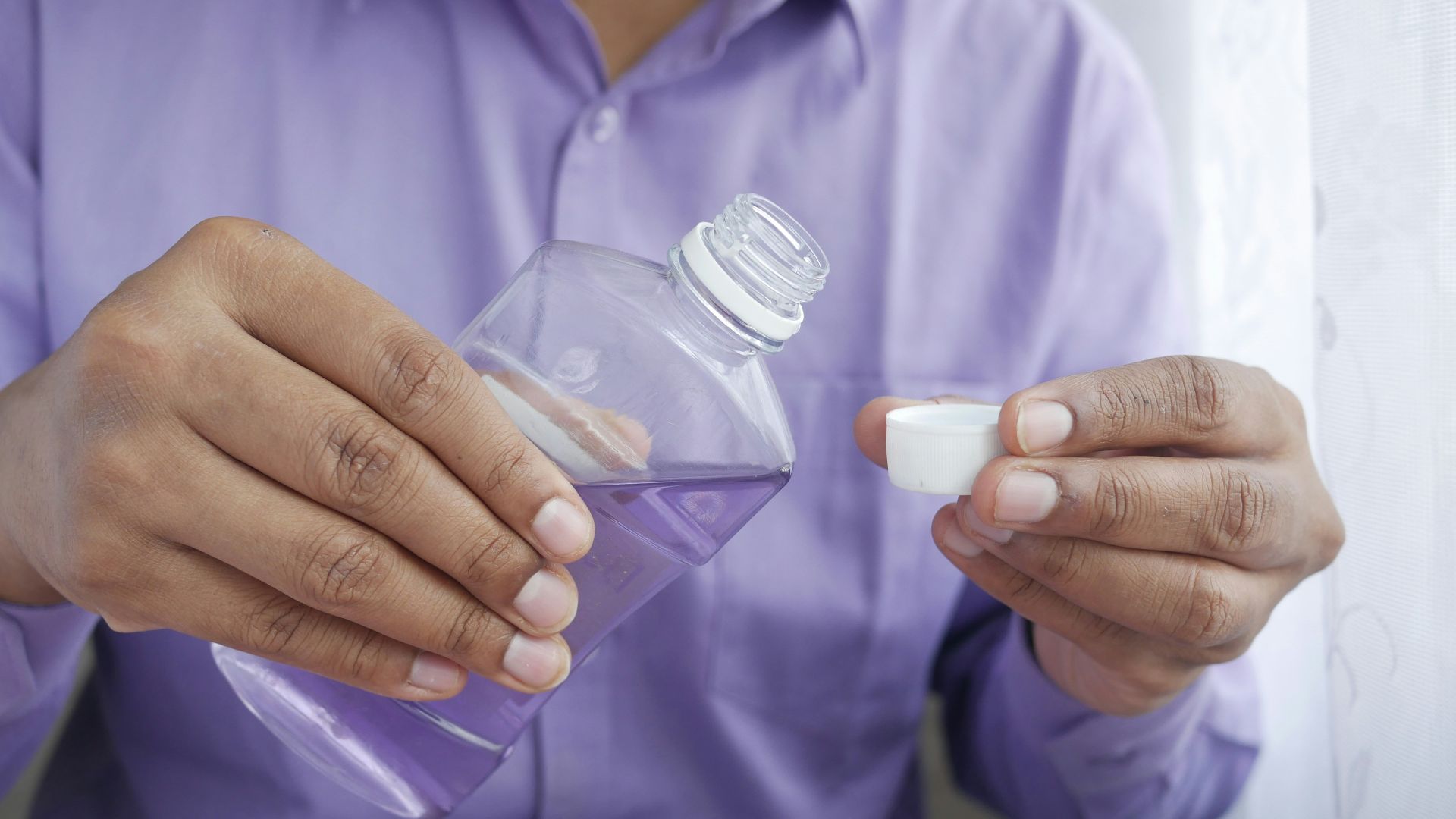 person holding white plastic bottle